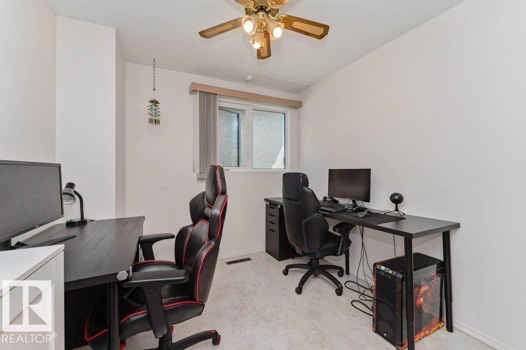 Bright room featuring a window with a valance, light-colored carpeting, a ceiling fan with integrated lighting, and neutral wall tones - 11415 56 Avenue Nw, Edmonton, AB