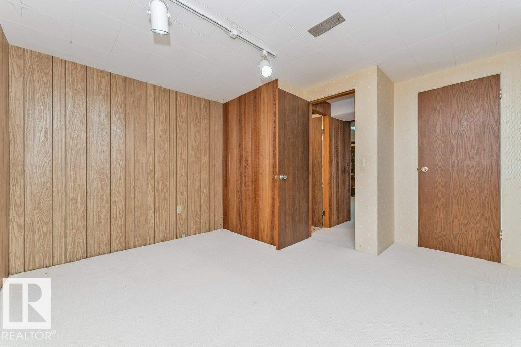 Room with paneling walls, track lighting, and a neutral carpet - 11415 56 Avenue Nw, Edmonton, AB