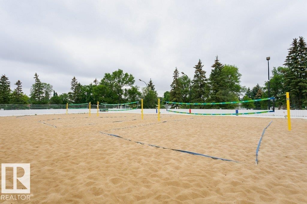 Sand volleyball court with multiple nets, boundary lines, and a surrounding white fence - 11415 56 Avenue Nw, Edmonton, AB