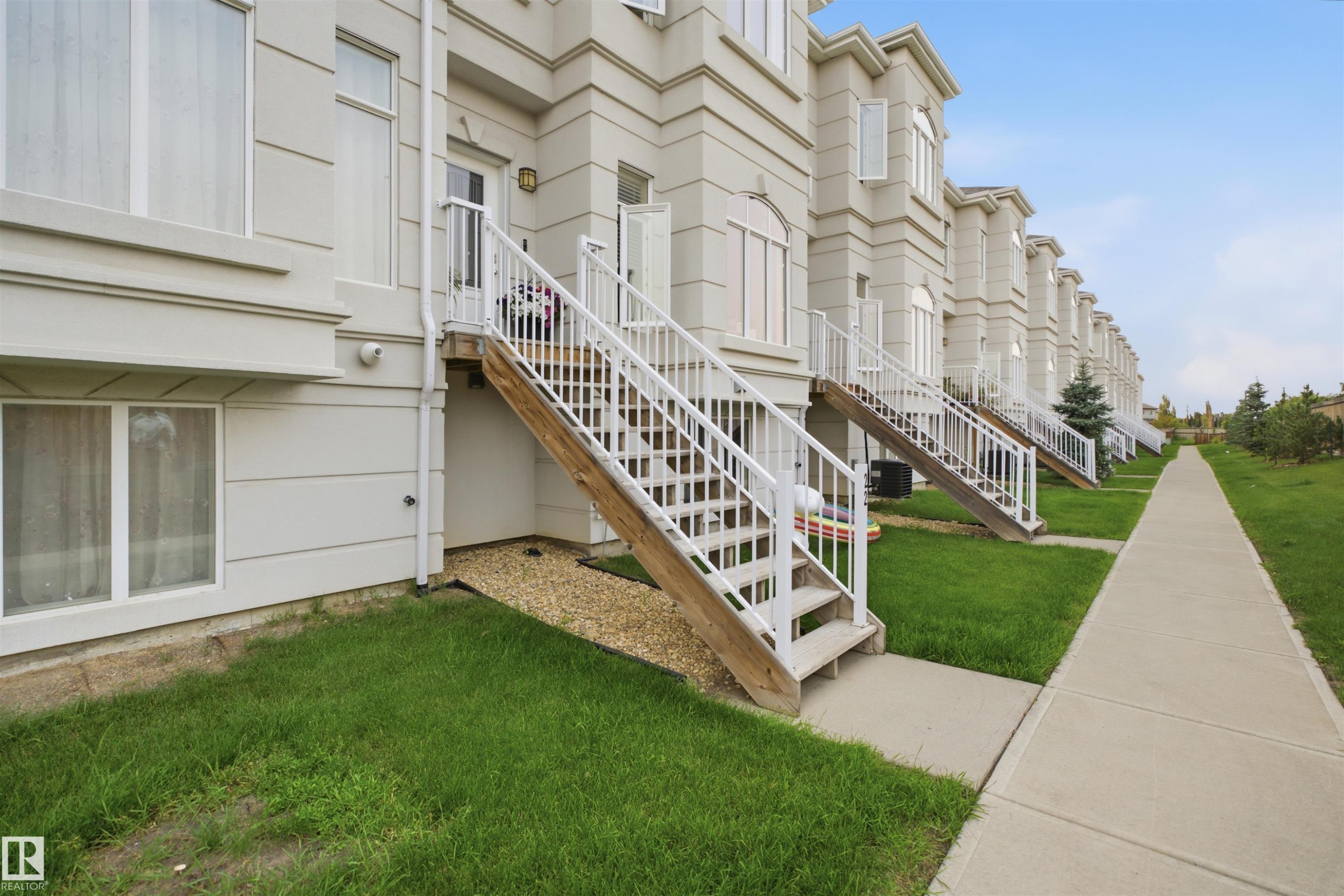 Exterior features include a private entry staircase, lower-level windows, and a concrete walkway - #22 723 172 Street Sw, Edmonton, AB