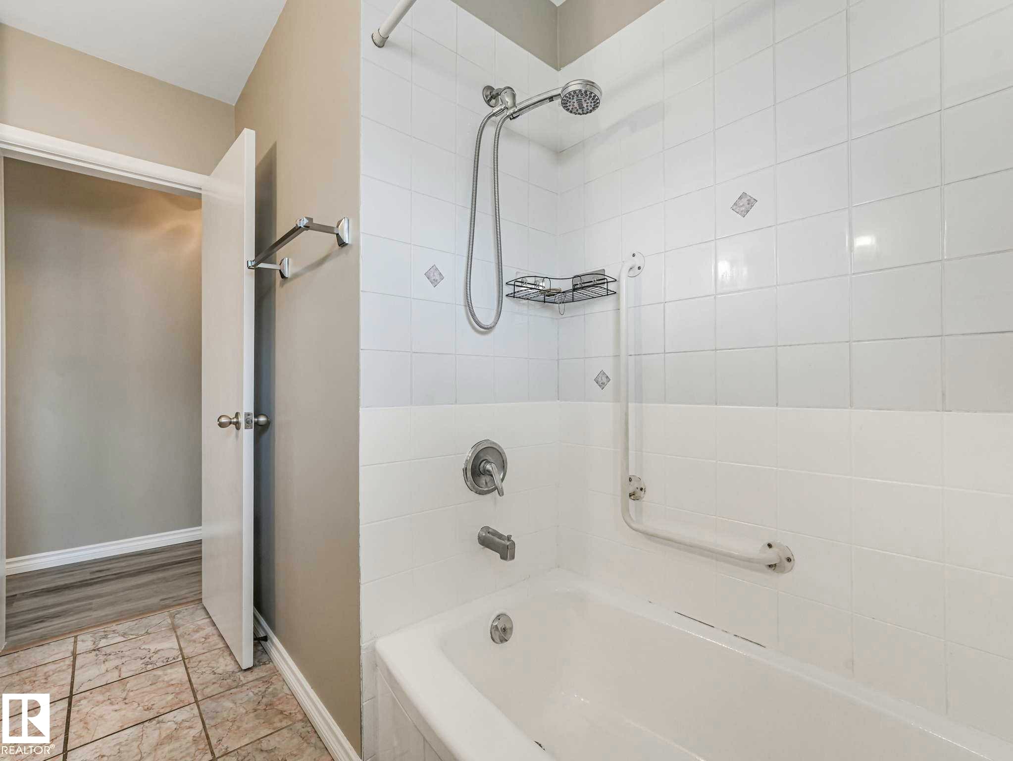 White tiled shower with a handheld showerhead and a built-in grab bar - 15916 88B Avenue Nw, Edmonton, AB