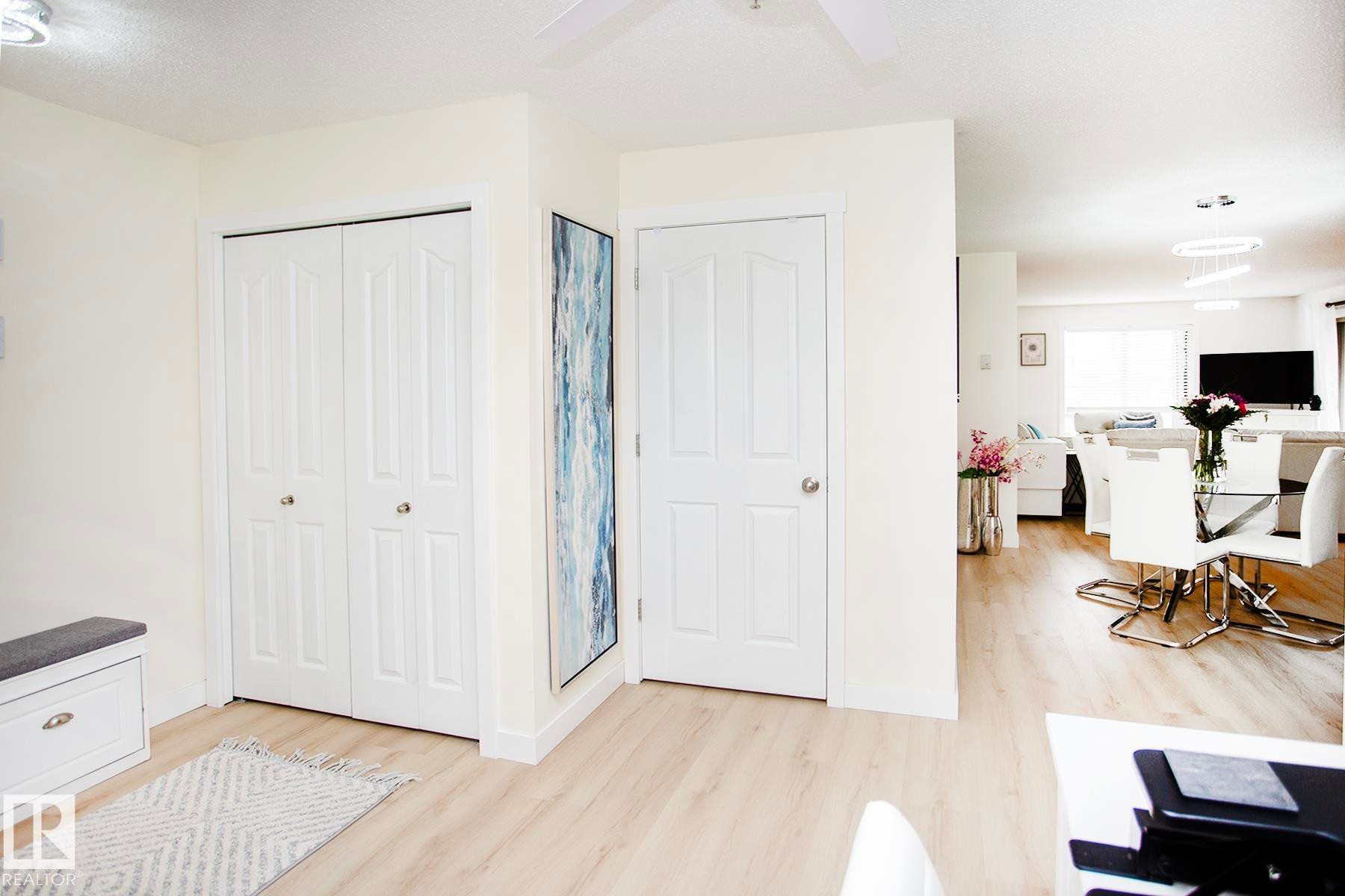 Wood-finish flooring, white paneled doors, ceiling fan, and recessed lighting - #201 1070 Mcconachie Bv Nw, Edmonton, AB