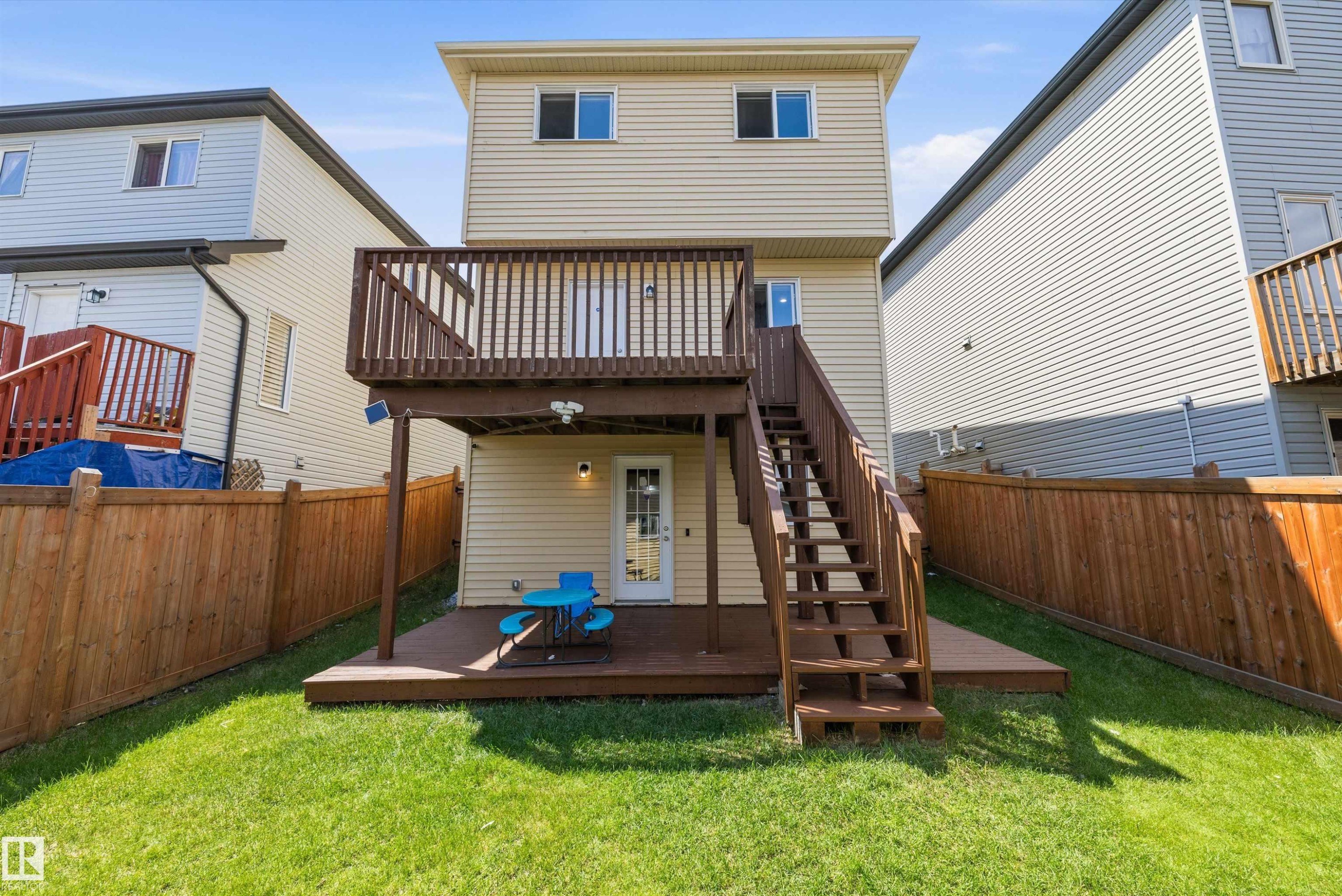 Two-story exterior with siding, featuring a multi-level wooden deck and stairs - 2803 12 Street Nw, Edmonton, AB