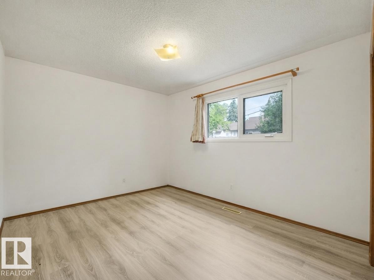 Wood-finish flooring, white walls, and a window with white trim - 16428 88 Avenue Nw, Edmonton, AB
