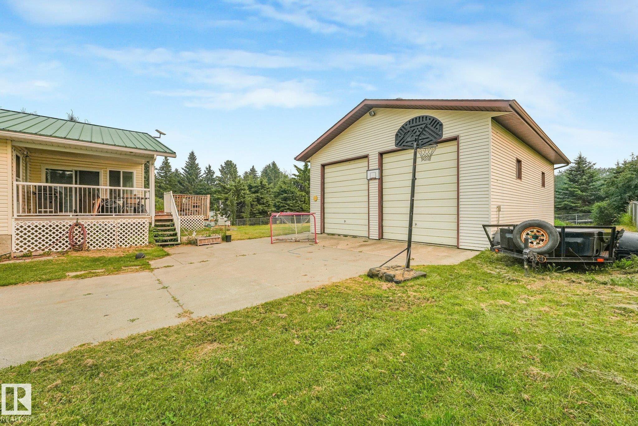 Detached two-car garage with light-colored siding and a brown trim roof - 54 Buskmose Dr, Rural Wetaskiwin County, AB - Outdoor With Deck Patio Veranda With Exterior
