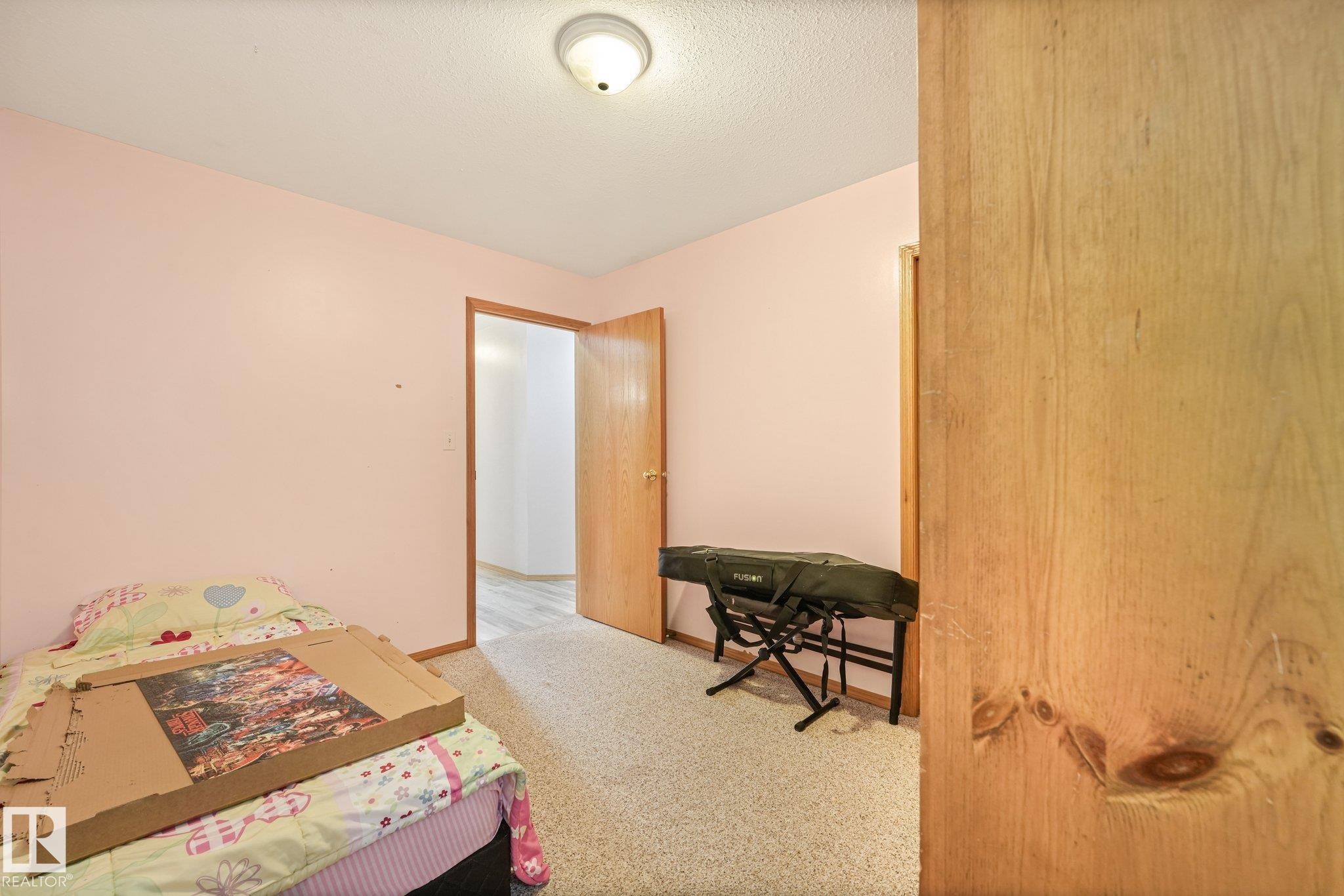 Carpeted flooring paired with neutral-toned walls and a ceiling-mounted light fixture - 54 Buskmose Dr, Rural Wetaskiwin County, AB - Indoor