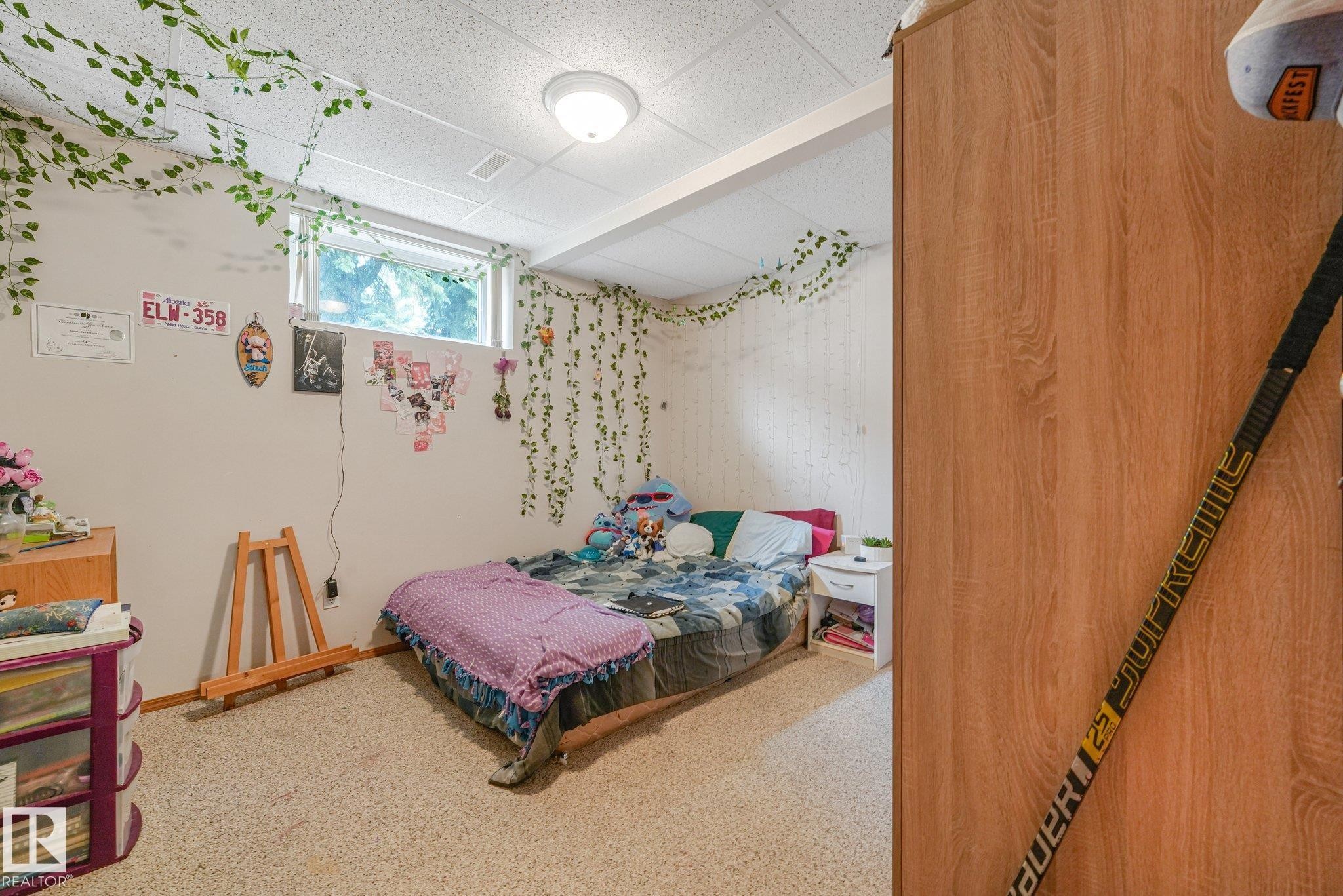 Carpeted room featuring a high window, a light-colored ceiling, and a flush-mount ceiling light fixture - 54 Buskmose Dr, Rural Wetaskiwin County, AB - Indoor Photo Showing Bedroom