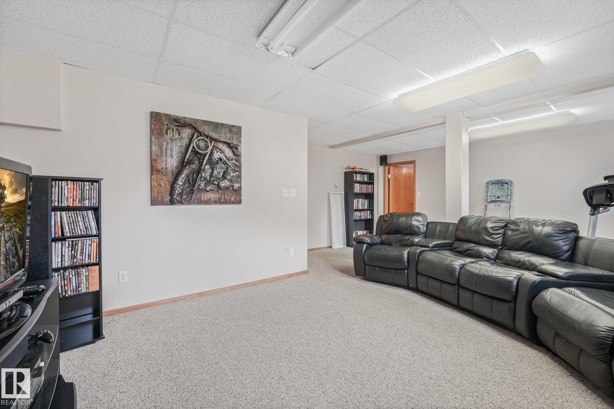 Carpeted room with a drop ceiling, white walls, and wood baseboards - 54 Buskmose Dr, Rural Wetaskiwin County, AB - Indoor