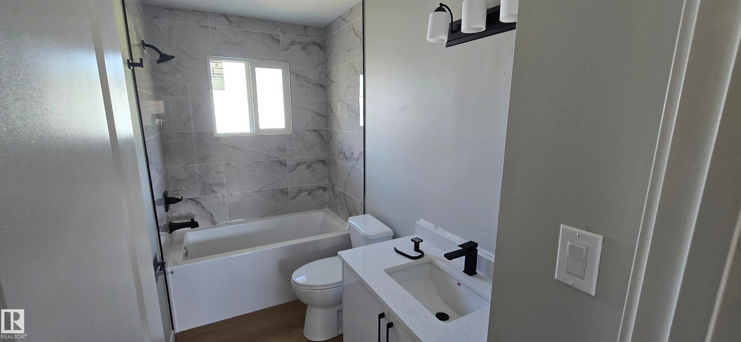 Vanity with a quartz countertop, integrated sink, and matte black faucet - 13812 63 Street Nw, Edmonton, AB
