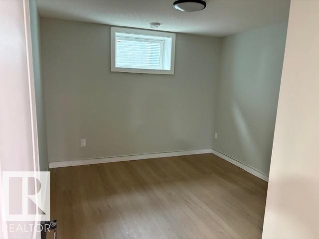 Recessed window with white trim, light neutral wall color, wood-finish flooring, and a flush mount ceiling light - 13812 63 Street Nw, Edmonton, AB