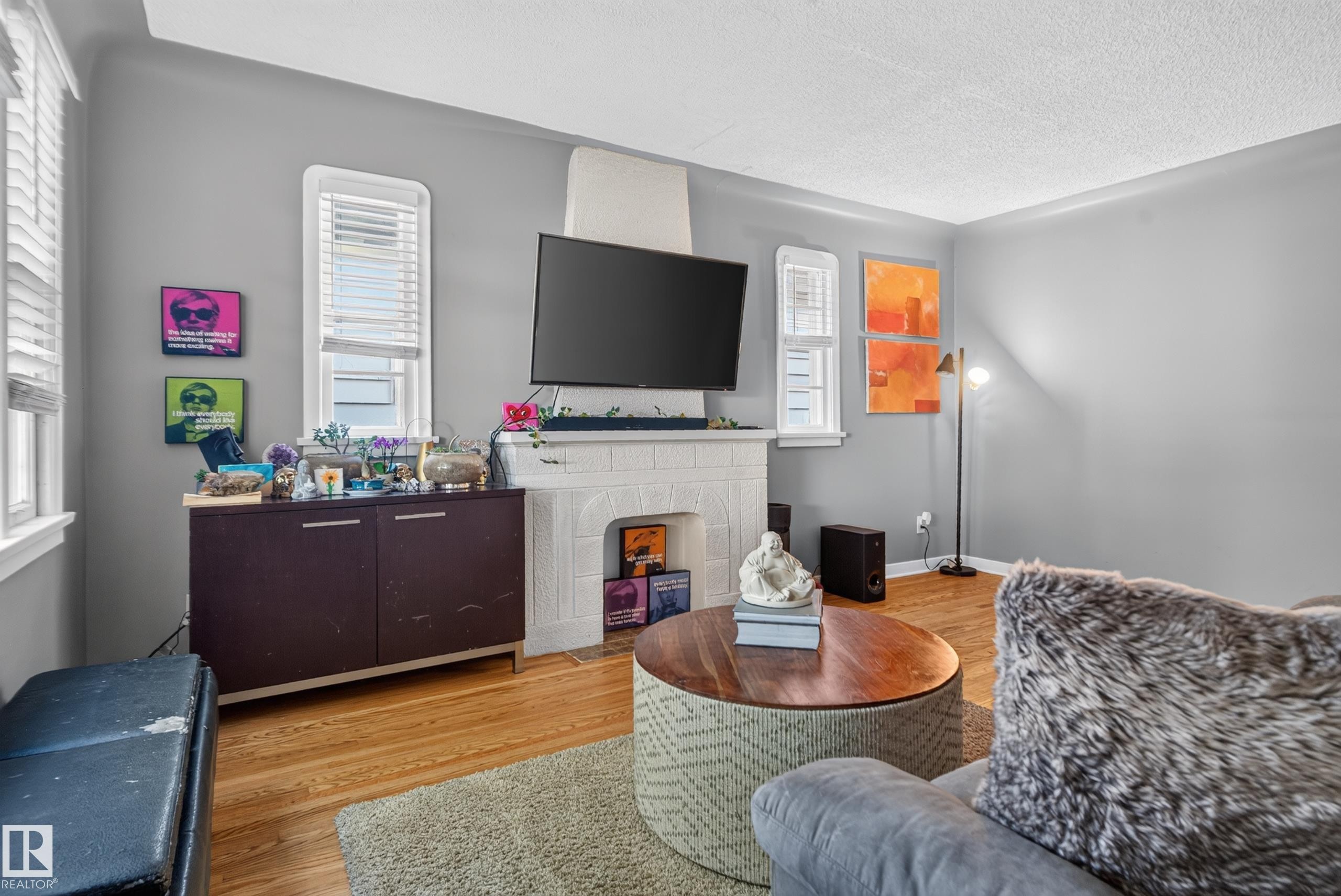 Hardwood flooring, painted gray walls, white trim, white window blinds, and a white fireplace surround - 11406 83 Street Nw, Edmonton, AB