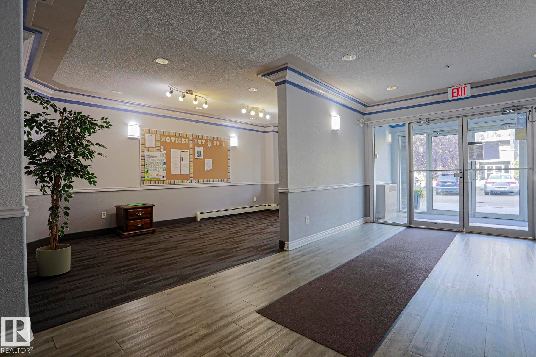 Wood-finish flooring, recessed lighting, and wall-mounted sconces - #108 1204 156 St Nw, Edmonton, AB
