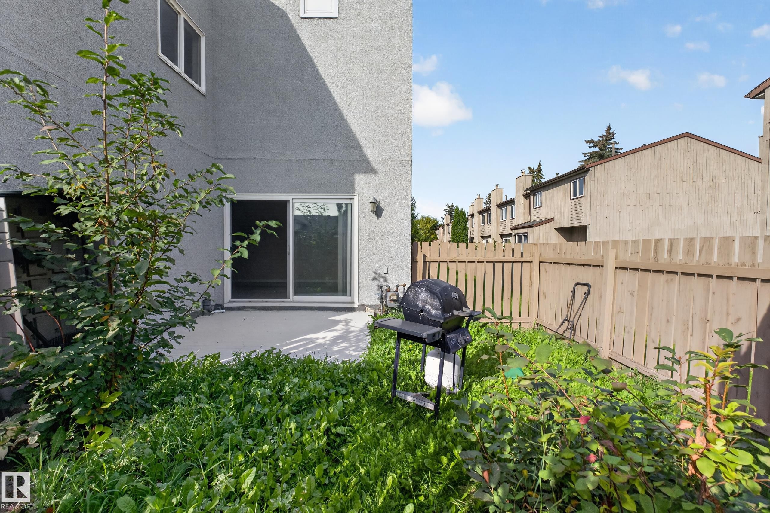 Paved patio space with a sliding glass door and exterior lighting - 17749 95 Street Nw, Edmonton, AB