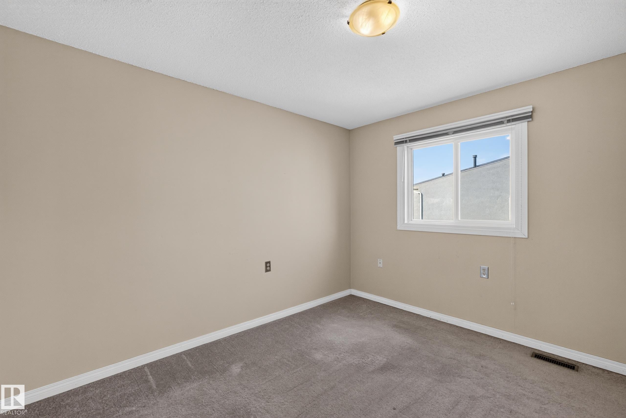 Neutral wall color, wall-to-wall carpeting, single window, flush mount lighting, and white trim - 17749 95 Street Nw, Edmonton, AB