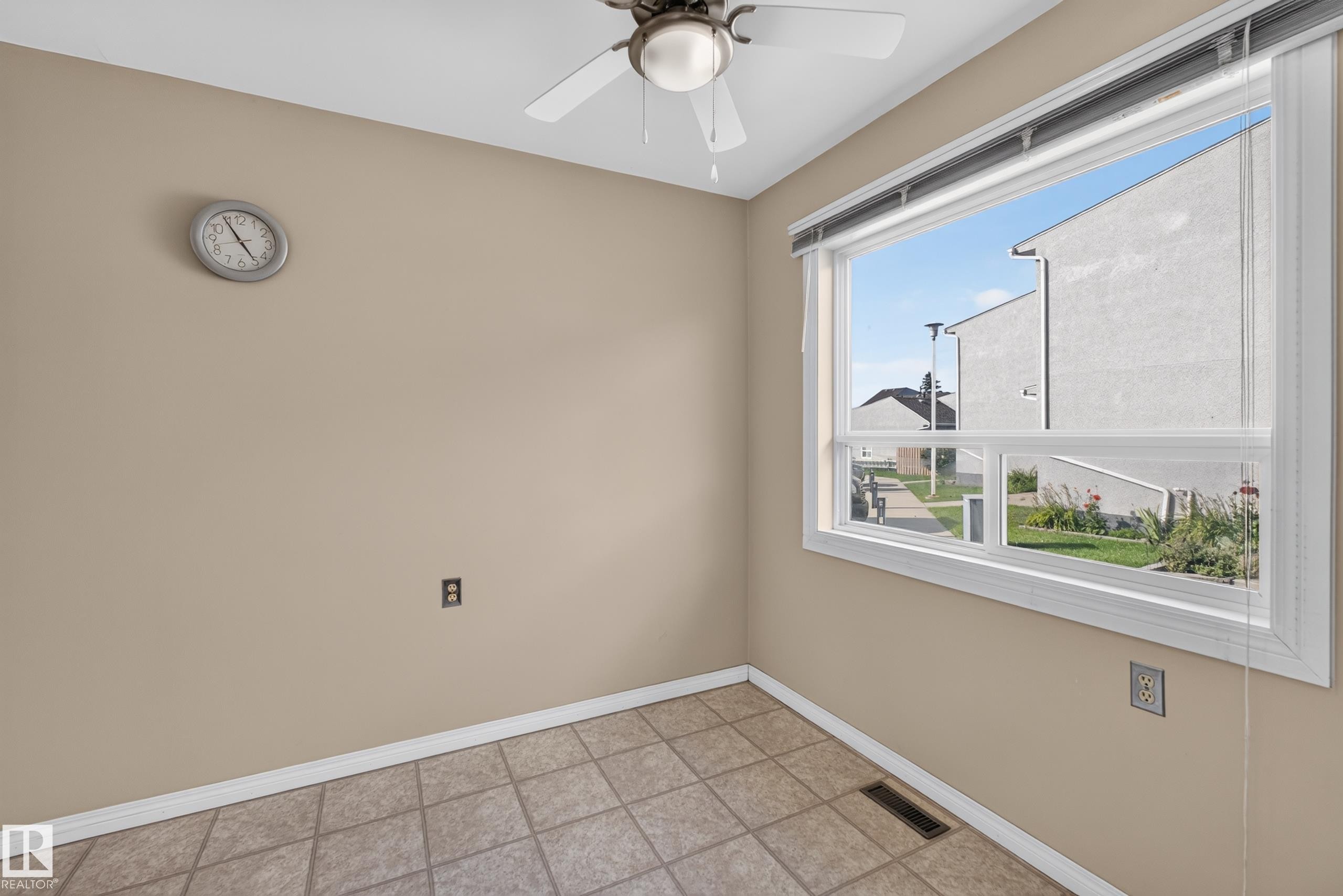 Expansive window with roller shades, tiled flooring, and a ceiling fan - 17749 95 Street Nw, Edmonton, AB