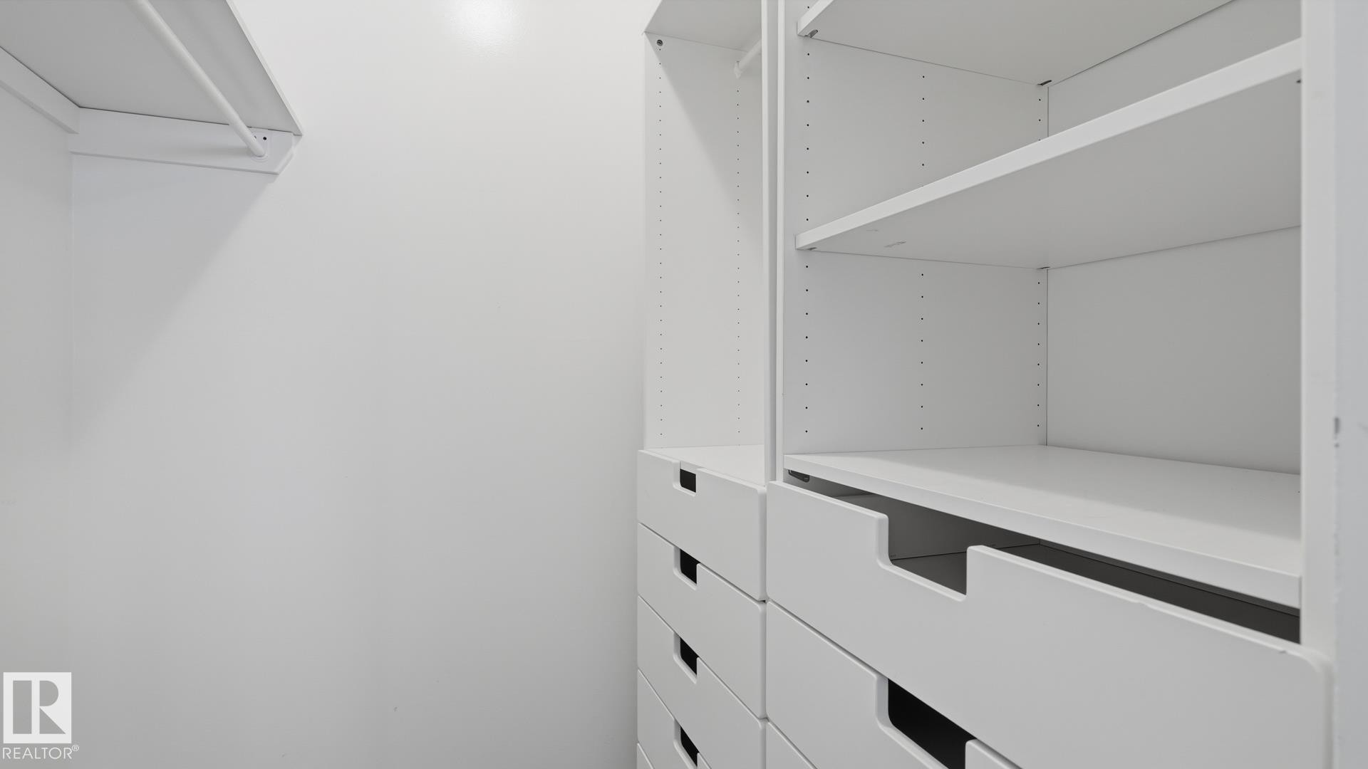 Built-in closet organization system featuring adjustable shelving and integrated drawers - 12208 146 Avenue Nw, Edmonton, AB