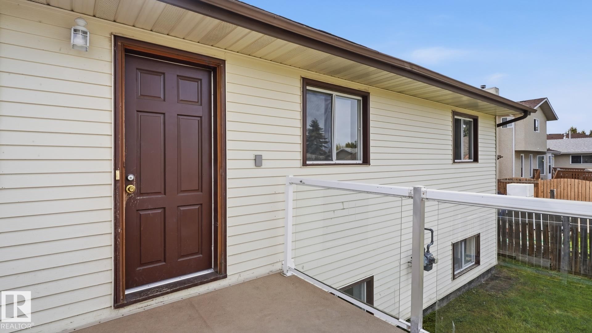 Cream-colored siding exterior with a dark brown entry door and trim - 12208 146 Avenue Nw, Edmonton, AB