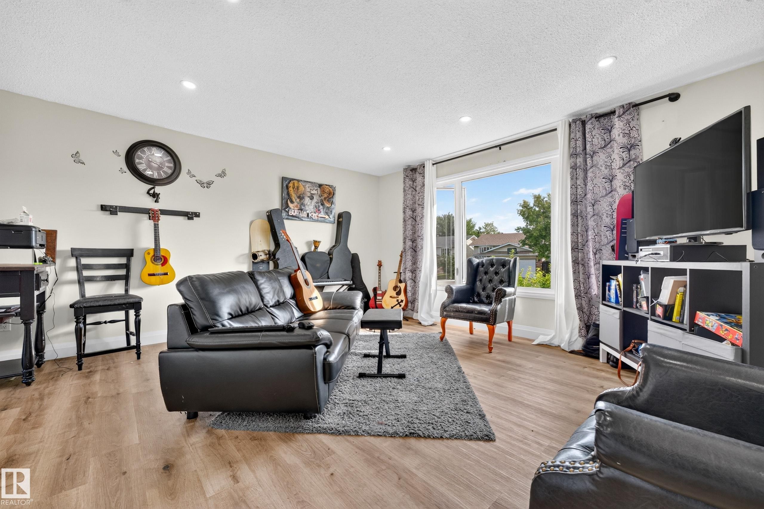 Recessed ceiling lighting, wood-finish flooring, and a large window with white trim - 2412 80 Street Nw, Edmonton, AB