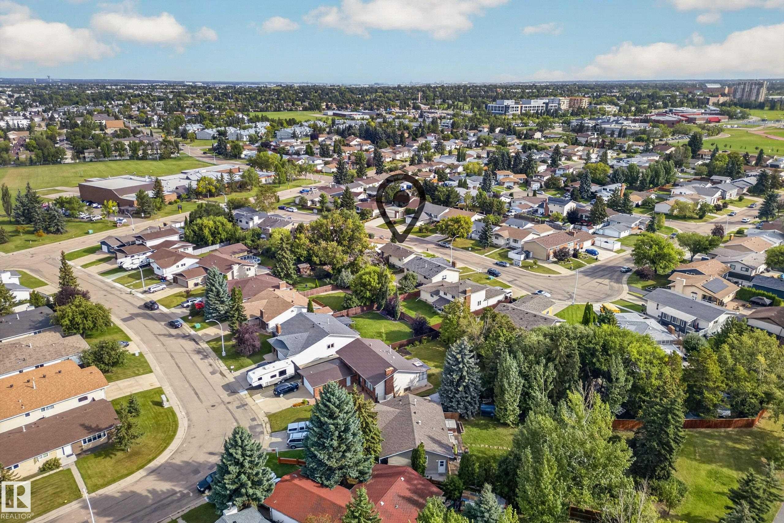 Residential neighborhood featuring mature trees, paved streets, and a mix of single-family homes - 2412 80 Street Nw, Edmonton, AB