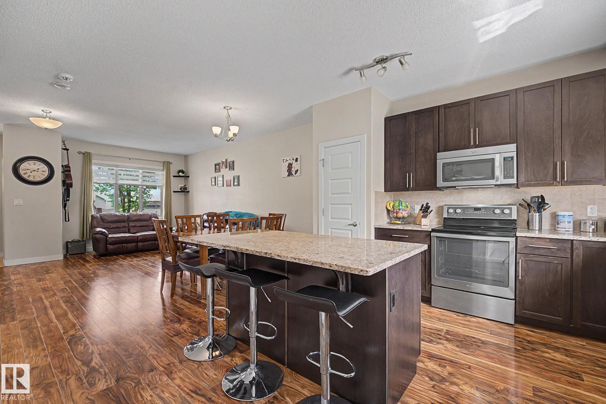 Open-concept layout featuring wood-finish flooring - 3343 Weidle Way Sw, Edmonton, AB