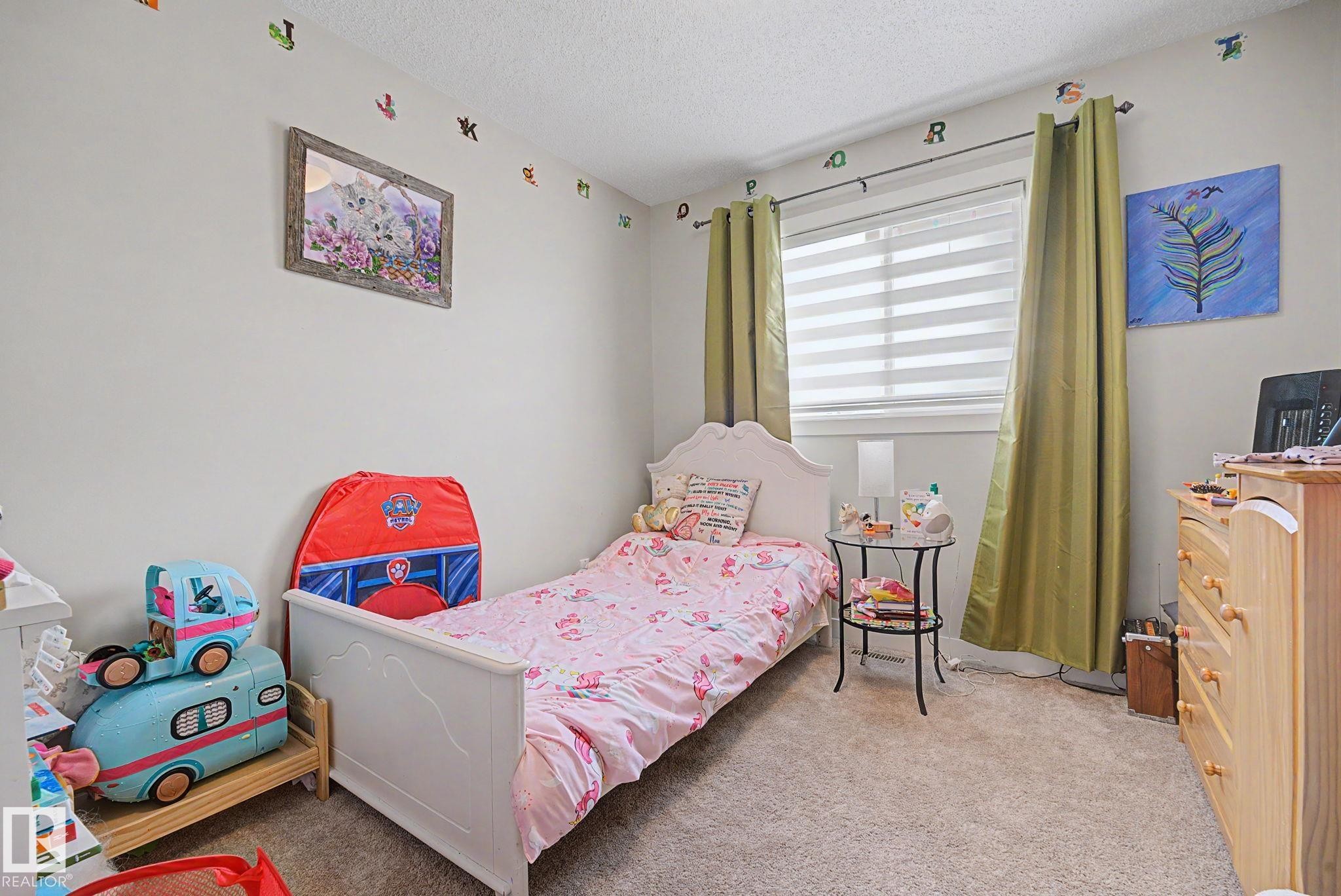 Carpeted room featuring a window with horizontal blinds and full-length drapes - 3343 Weidle Way Sw, Edmonton, AB