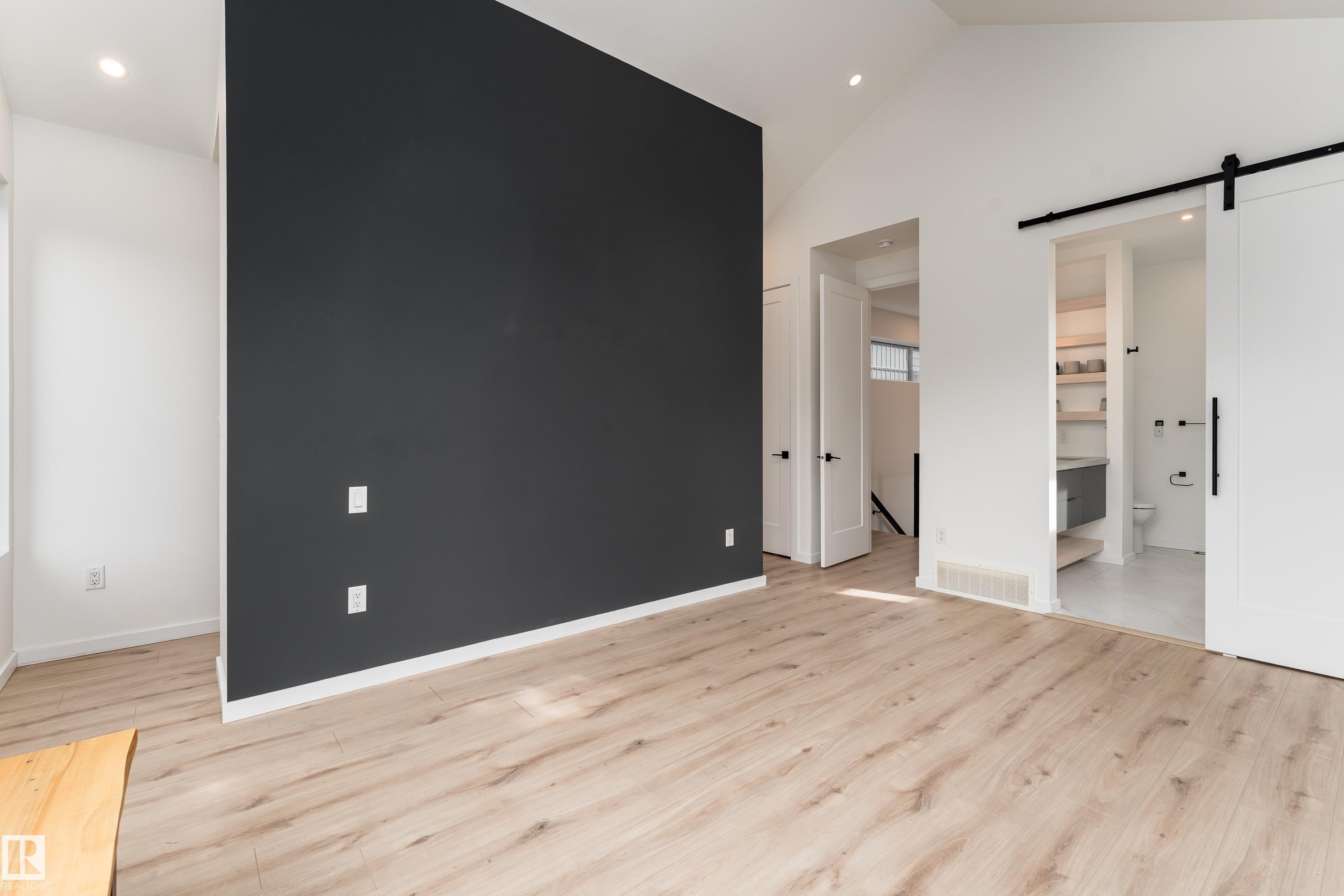 Vaulted ceiling, recessed lighting, wood-finish flooring, accent wall, and barn door entry - 10138 90 Street Nw, Edmonton, AB