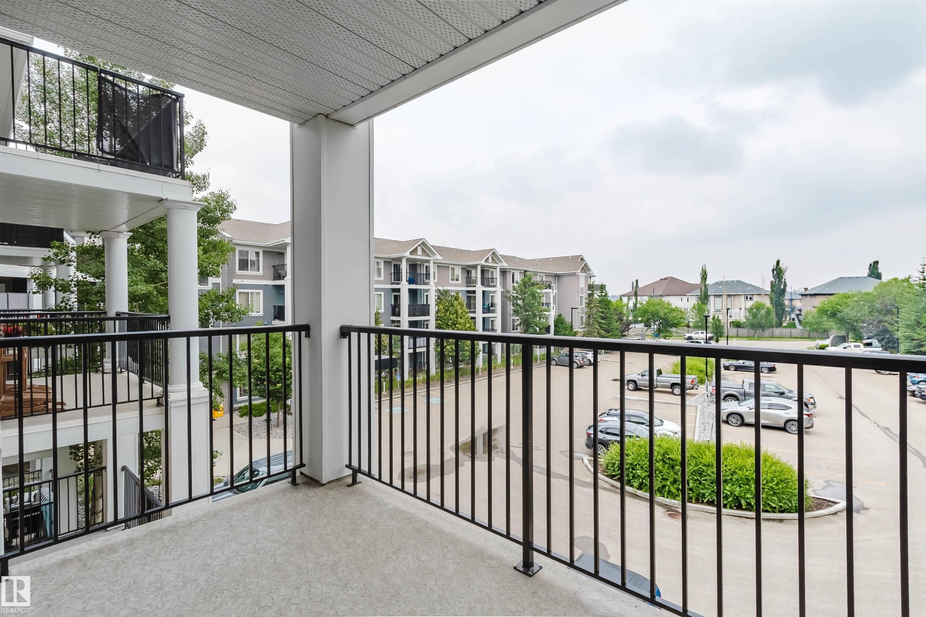 Balcony featuring a textured concrete surface and black metal railings - #304 6084 Stanton Dr Sw, Edmonton, AB - Outdoor With Balcony With Exterior