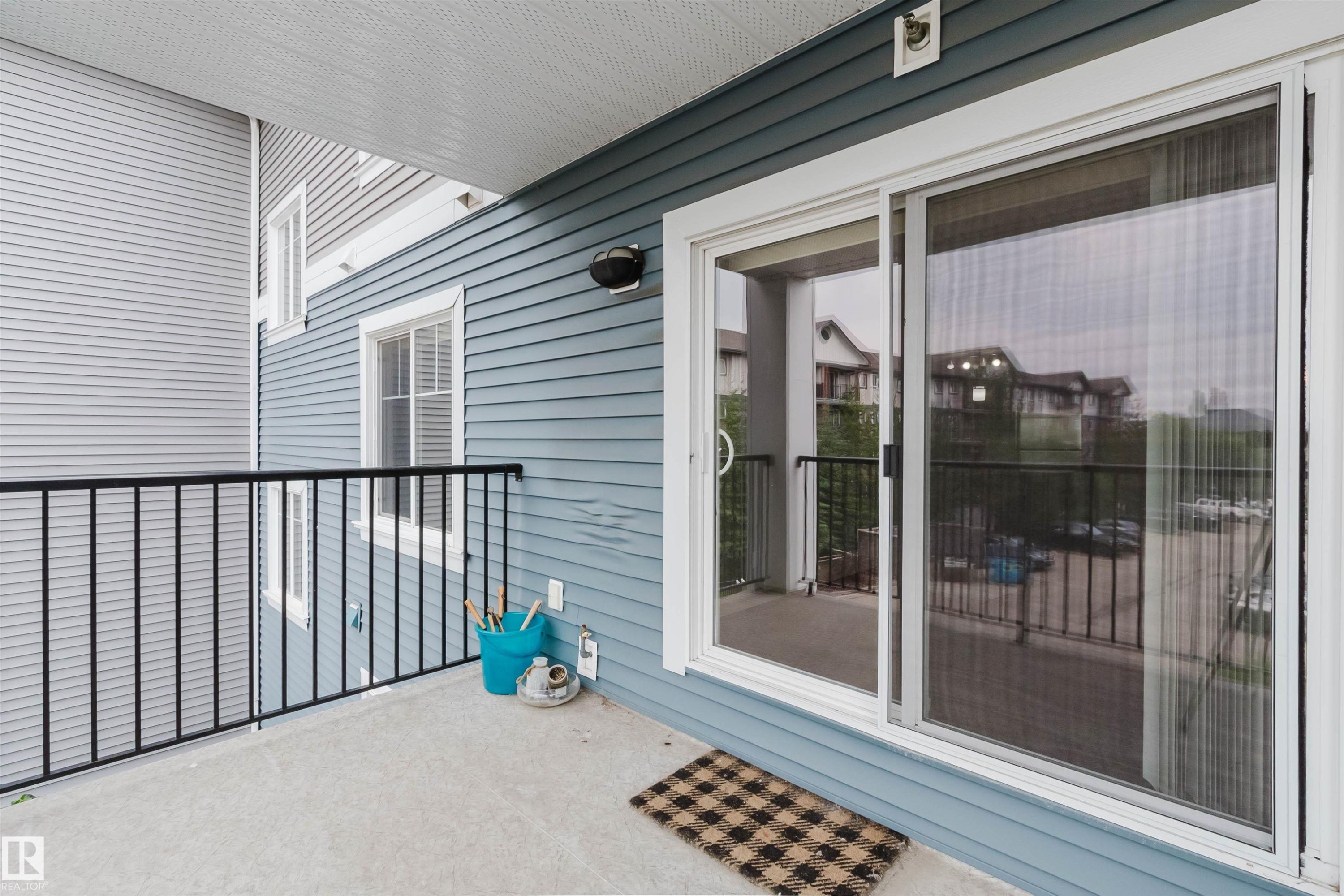 Private balcony with concrete flooring, black metal railing, and a sliding glass door entry - #304 6084 Stanton Dr Sw, Edmonton, AB - Outdoor With Balcony With Exterior