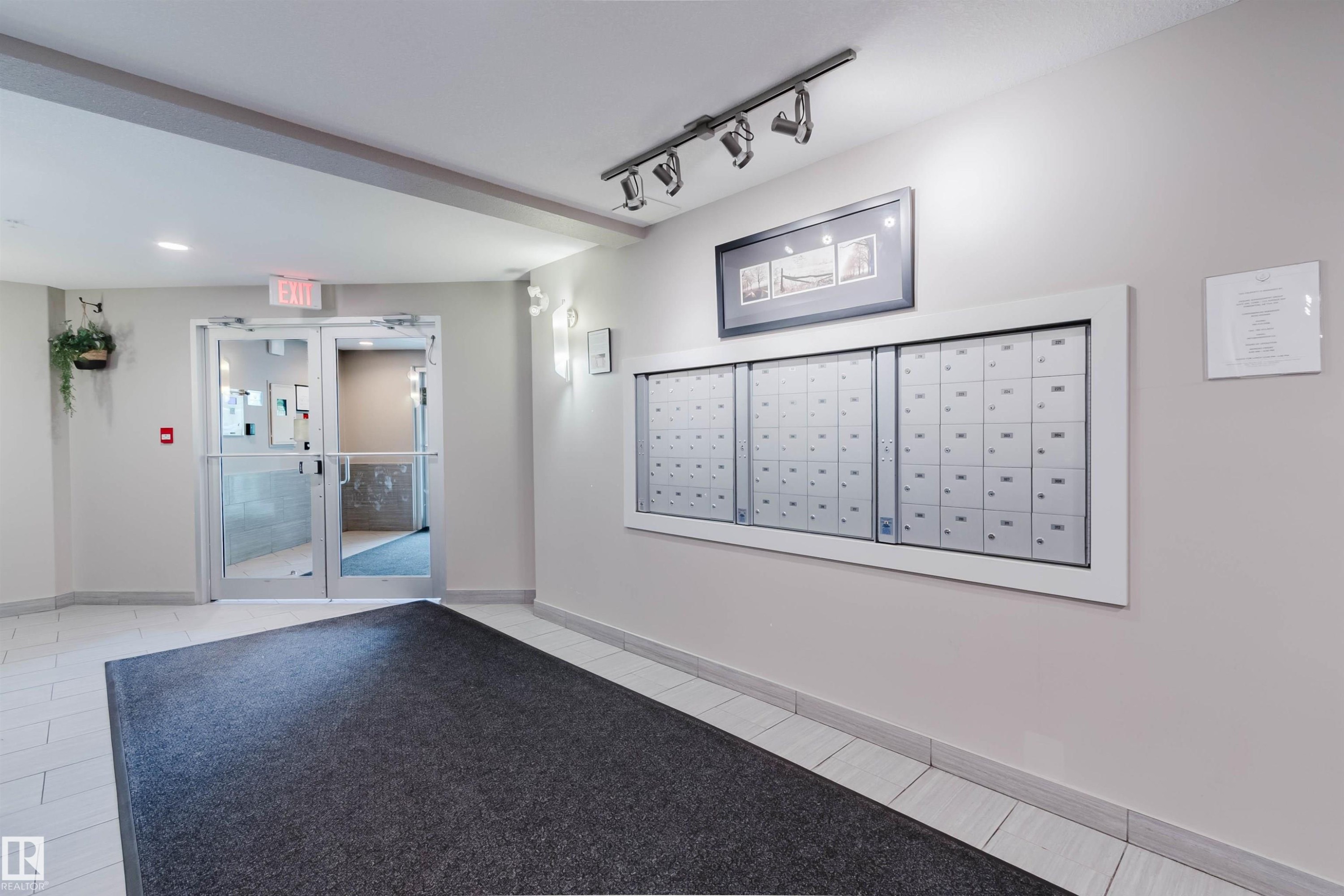 Mailbox wall with multiple individual compartments - #304 6084 Stanton Dr Sw, Edmonton, AB - Indoor Photo Showing Other Room