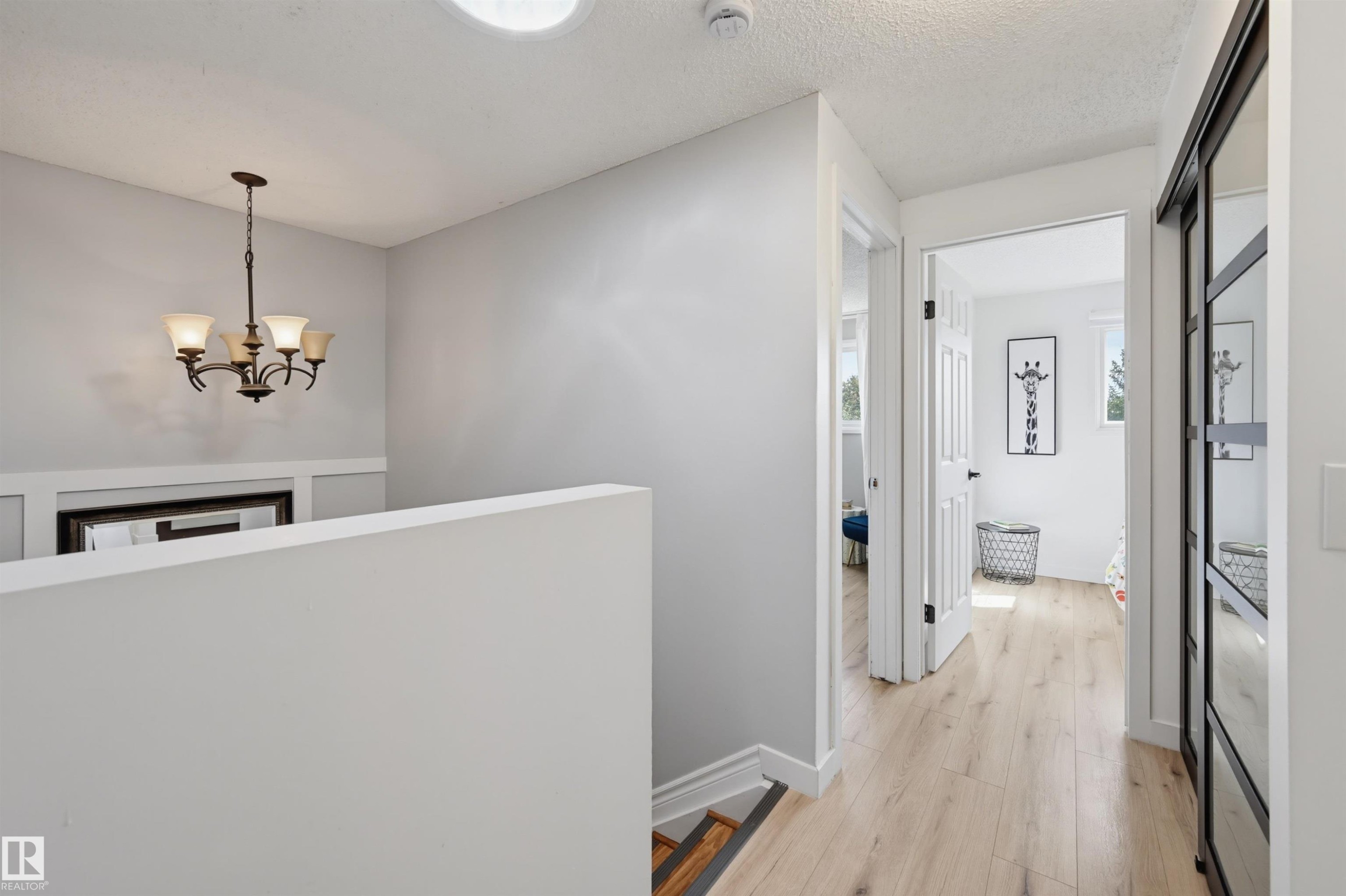 Wood-finish flooring, white walls, and a five-light chandelier - 4125 38 Street Nw, Edmonton, AB