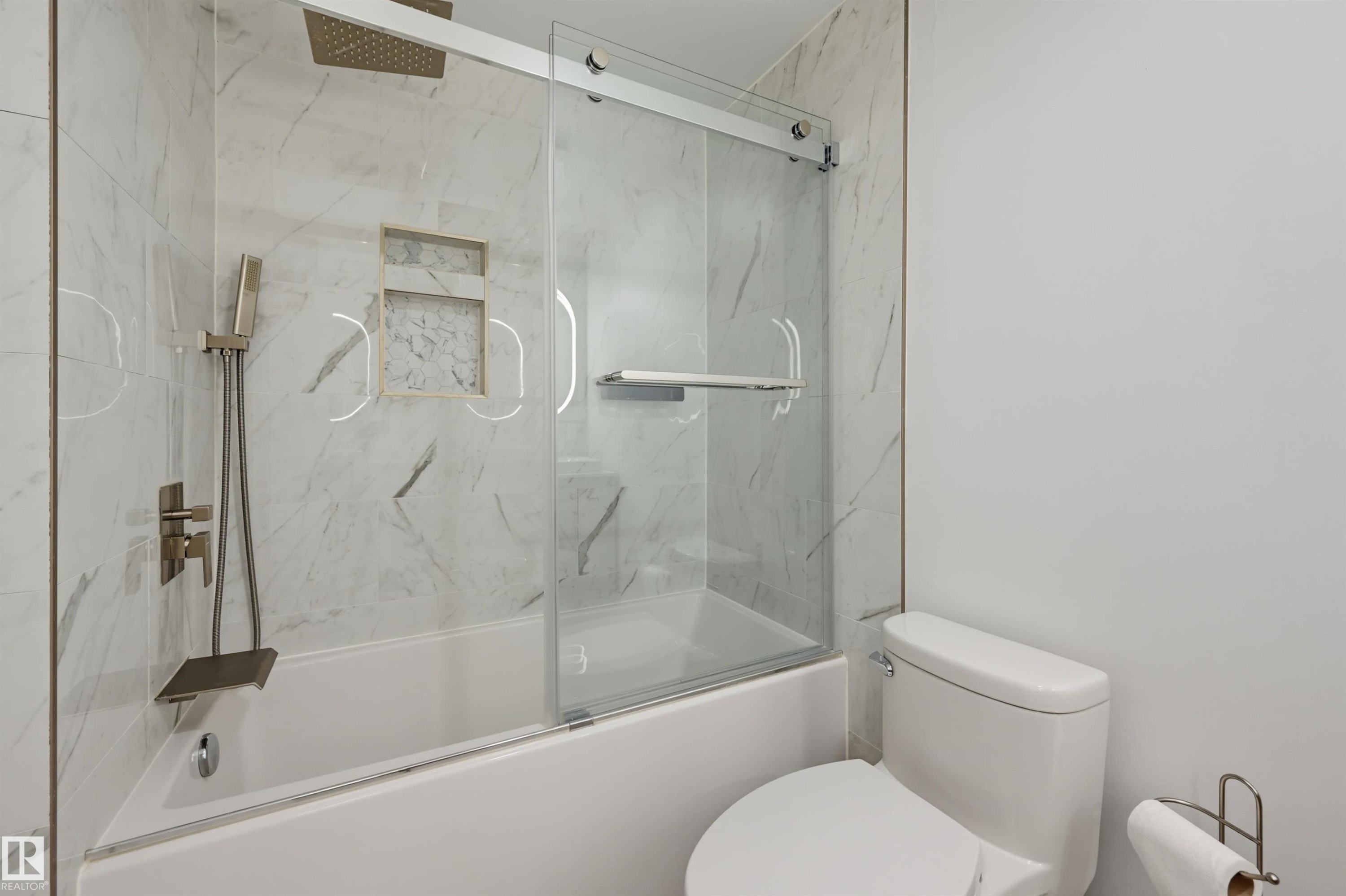 Bathtub with integrated shower, glass sliding shower door, recessed shower niche, and wall-mounted shower fixtures - 4125 38 Street Nw, Edmonton, AB
