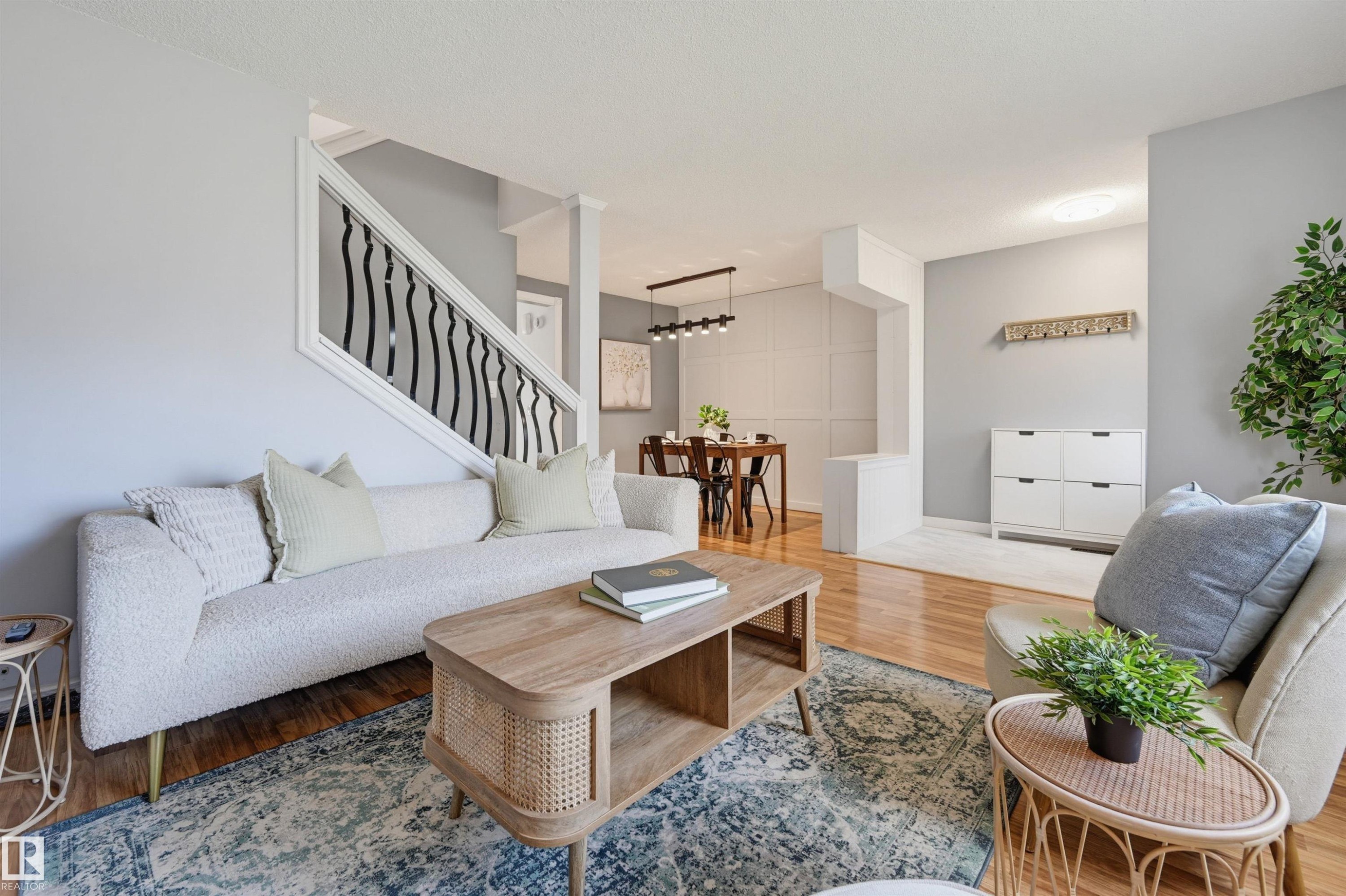 Hardwood-finish flooring, staircase with decorative wrought iron spindles, recessed lighting, dining area with modern linear chandelier, and wall paneling - 4125 38 Street Nw, Edmonton, AB