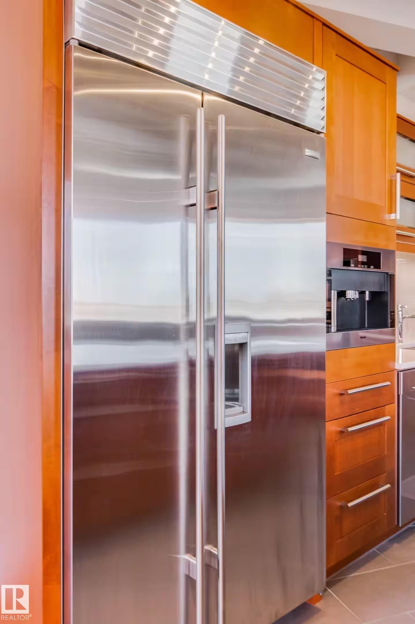 Stainless steel side-by-side refrigerator, integrated water and ice dispenser, custom wood-finish cabinetry, and built-in coffee system - #701 10105 109 St Nw, Edmonton, AB