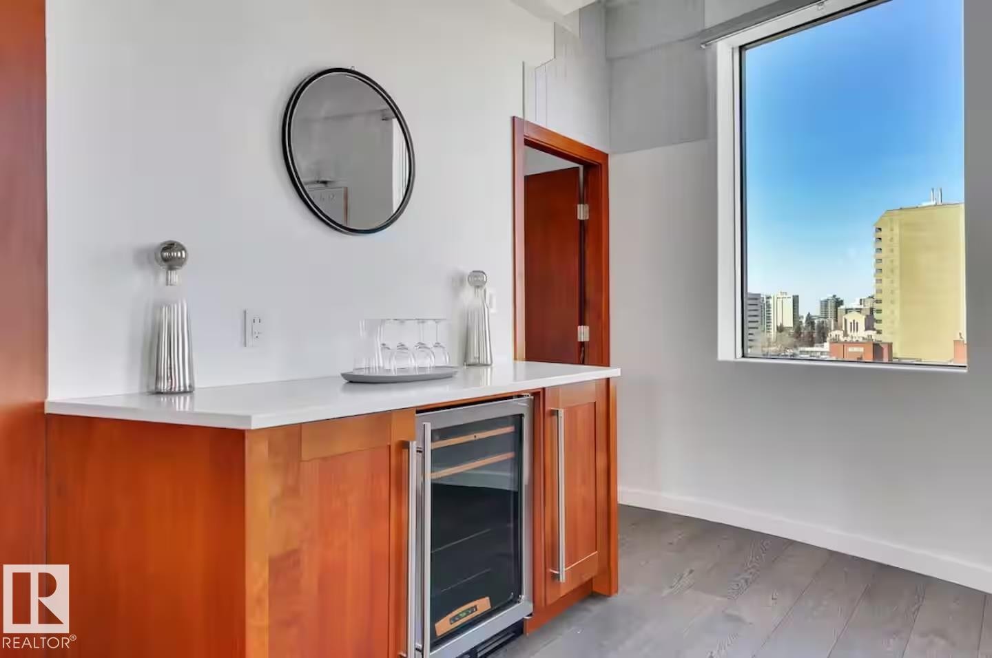 Built-in wood-finish cabinetry with a white countertop and integrated beverage cooler - #701 10105 109 St Nw, Edmonton, AB