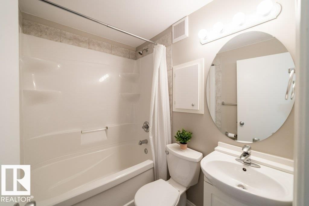 Alcove bathtub with integrated shelving and tiled surround - 12228 134 Street Nw, Edmonton, AB