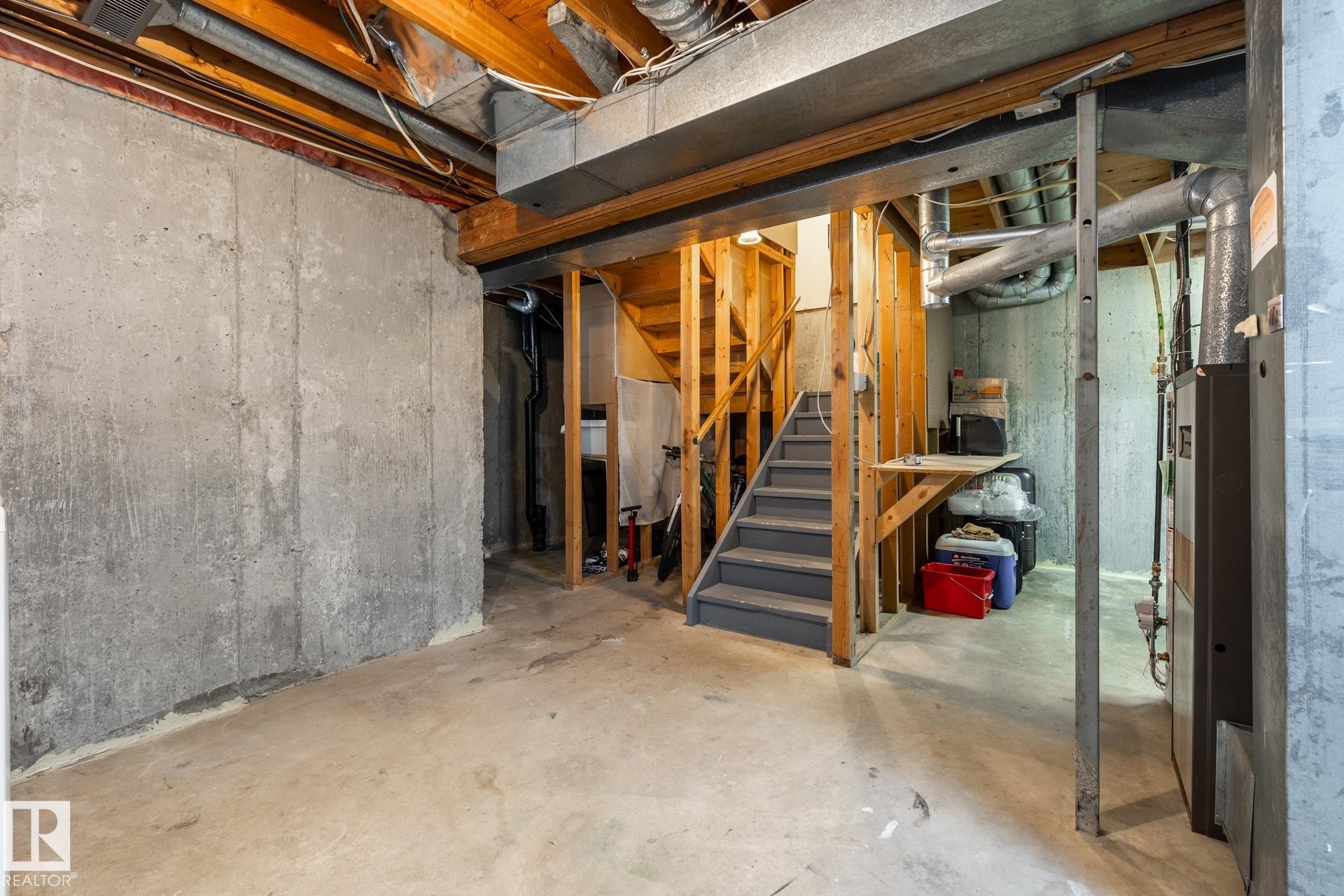 Unfinished basement with concrete flooring and exposed ceiling joists - #20 3812 20 Av Nw, Edmonton, AB