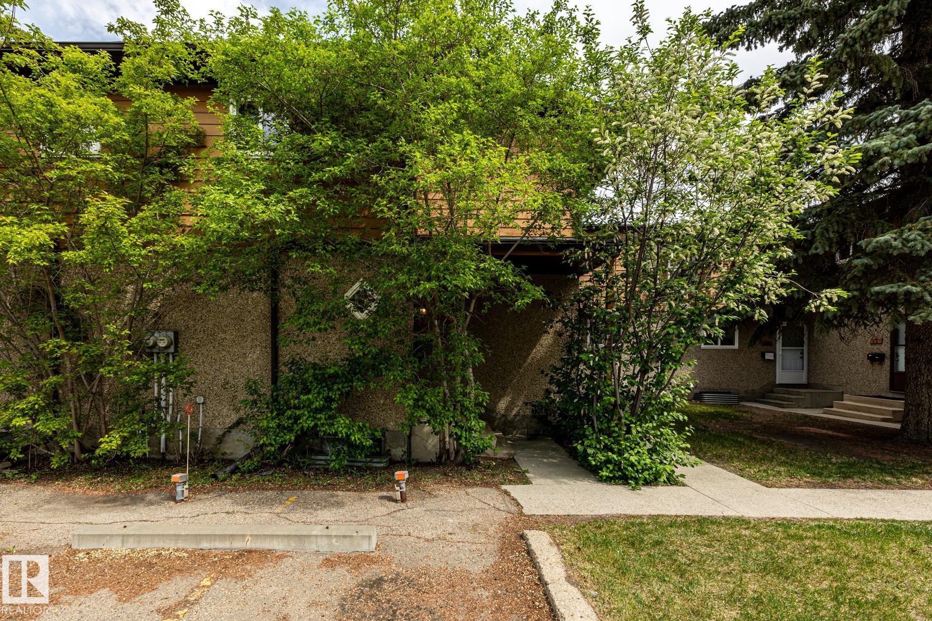 Multi-level exterior with textured stucco and wood-finish siding - #20 3812 20 Av Nw, Edmonton, AB