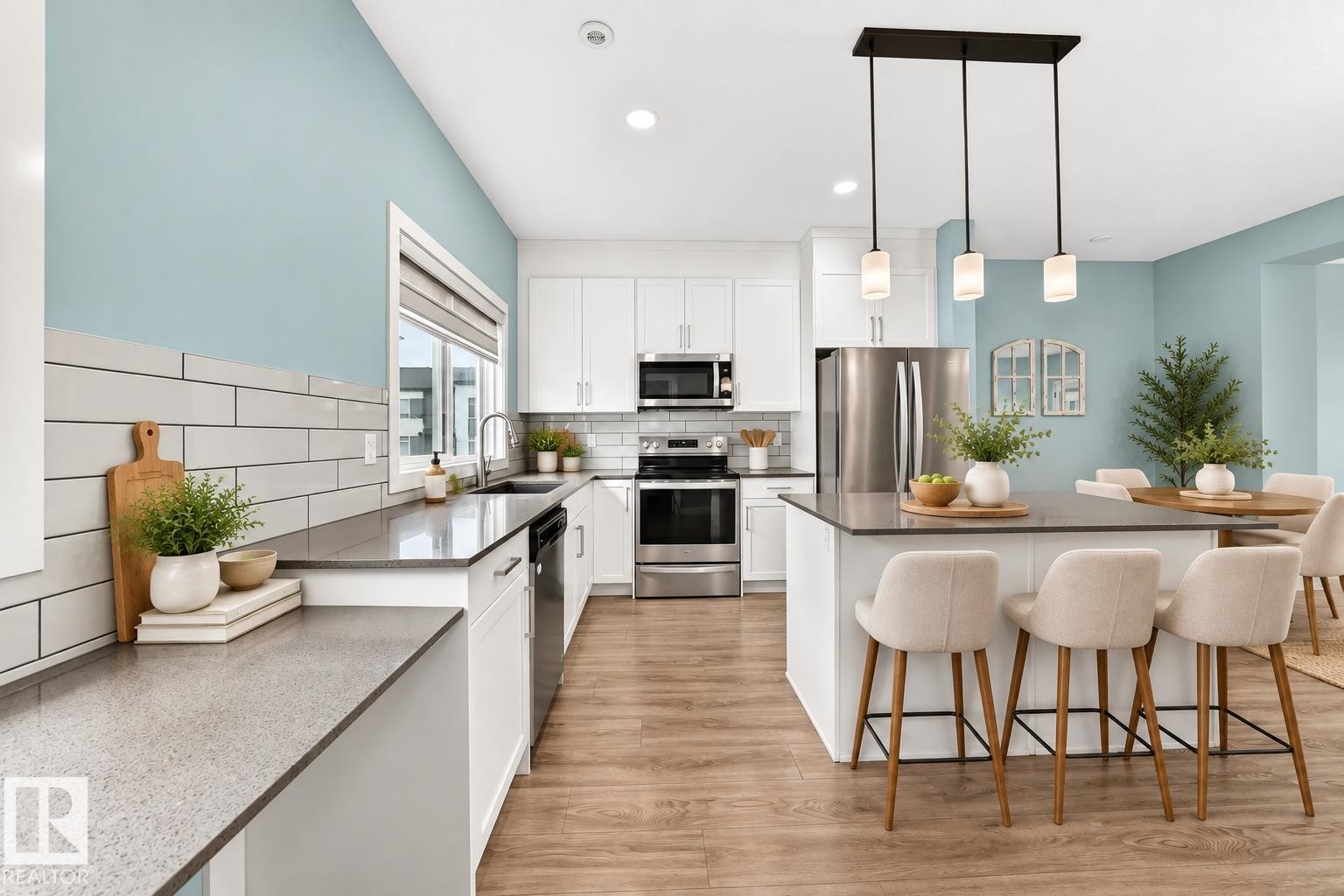 Modern kitchen featuring wood-finish flooring, white cabinetry, dark countertops, a white subway tile backsplash, and stainless steel appliances - #56 804 Welsh Dr Sw, Edmonton, AB