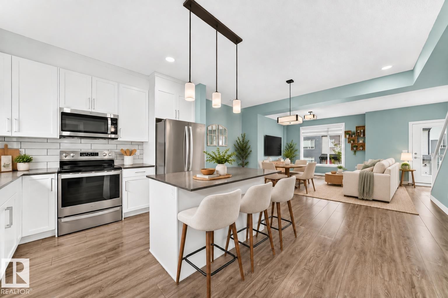 Kitchen featuring white shaker cabinetry, stainless steel appliances, and a central island with countertop seating - #56 804 Welsh Dr Sw, Edmonton, AB