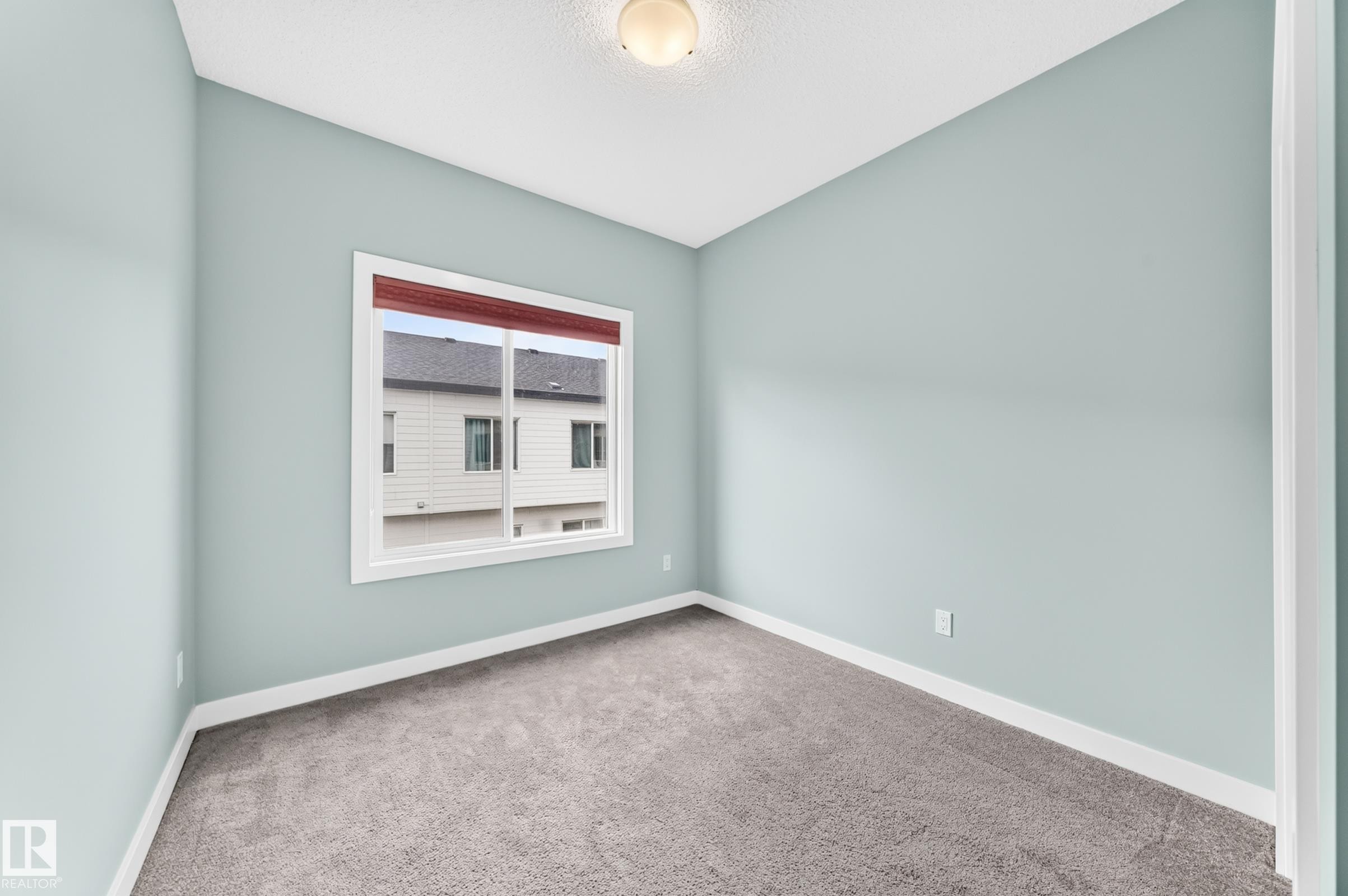 Light-colored carpeting with white trim, light blue painted walls, and a single window - #56 804 Welsh Dr Sw, Edmonton, AB