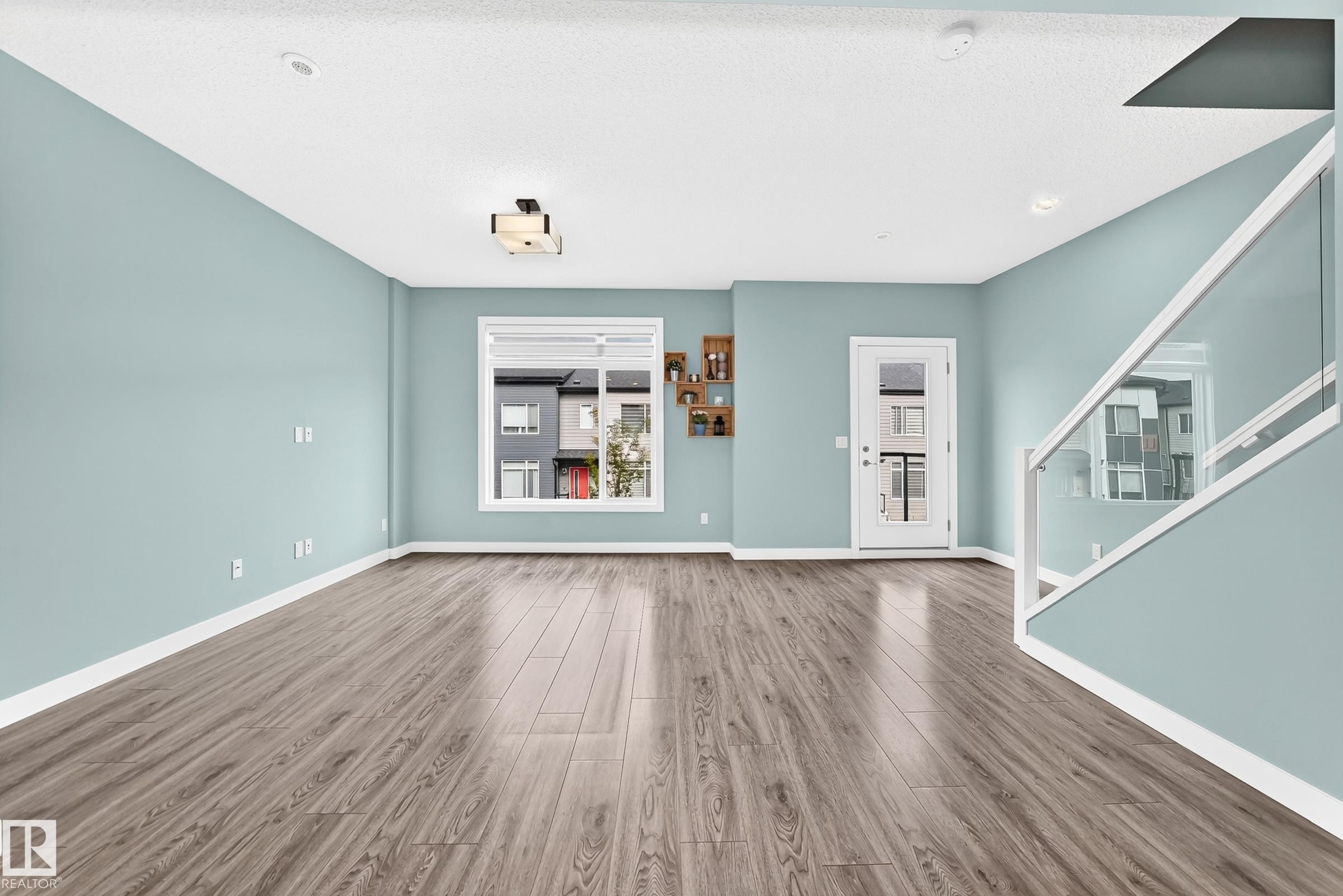Wood-finish flooring throughout, light blue wall paint, white trim, and a white ceiling - #56 804 Welsh Dr Sw, Edmonton, AB