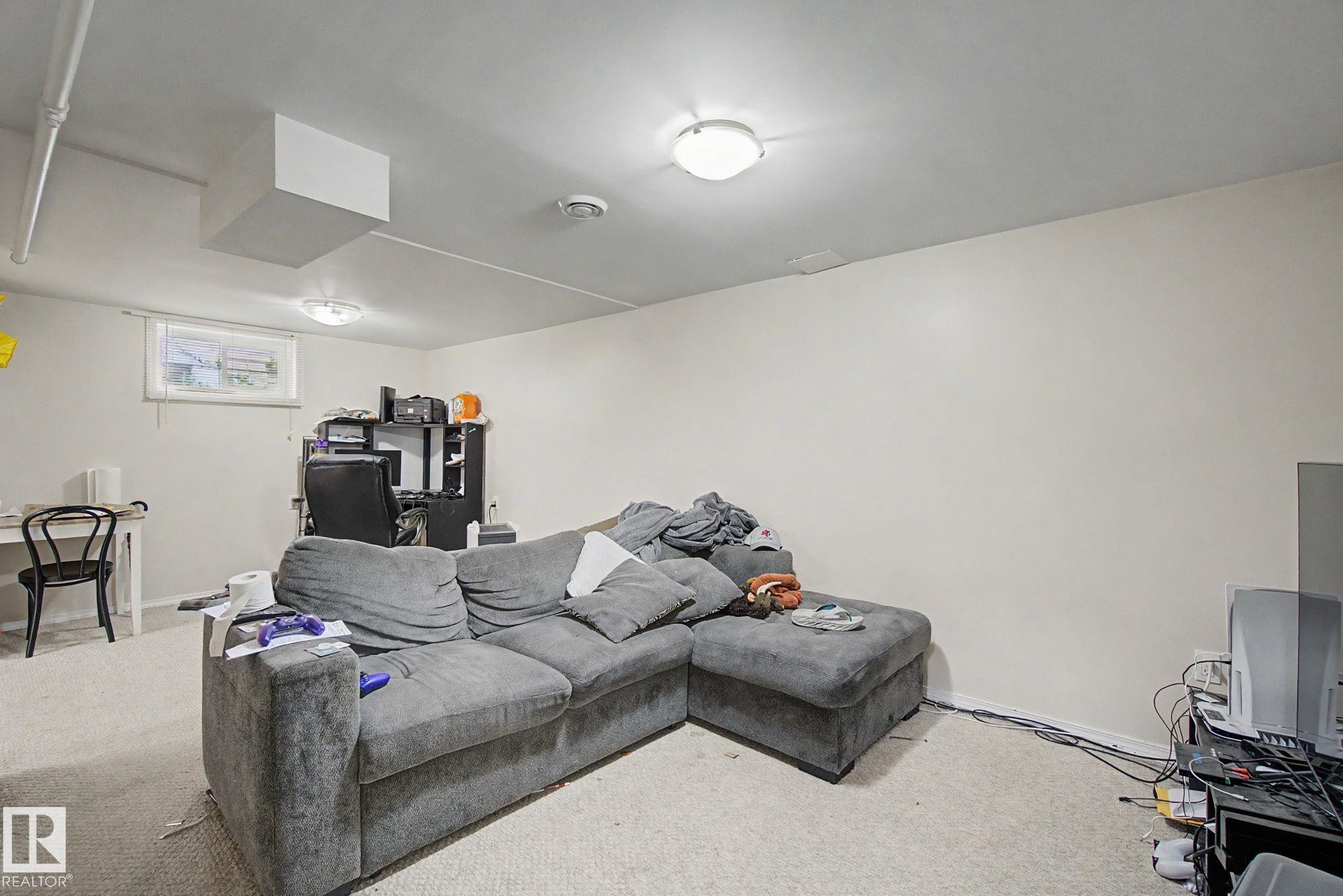 Finished room featuring a window, light-toned carpeting, and flush-mount ceiling lighting - 8710 83 Avenue Nw, Edmonton, AB - Indoor
