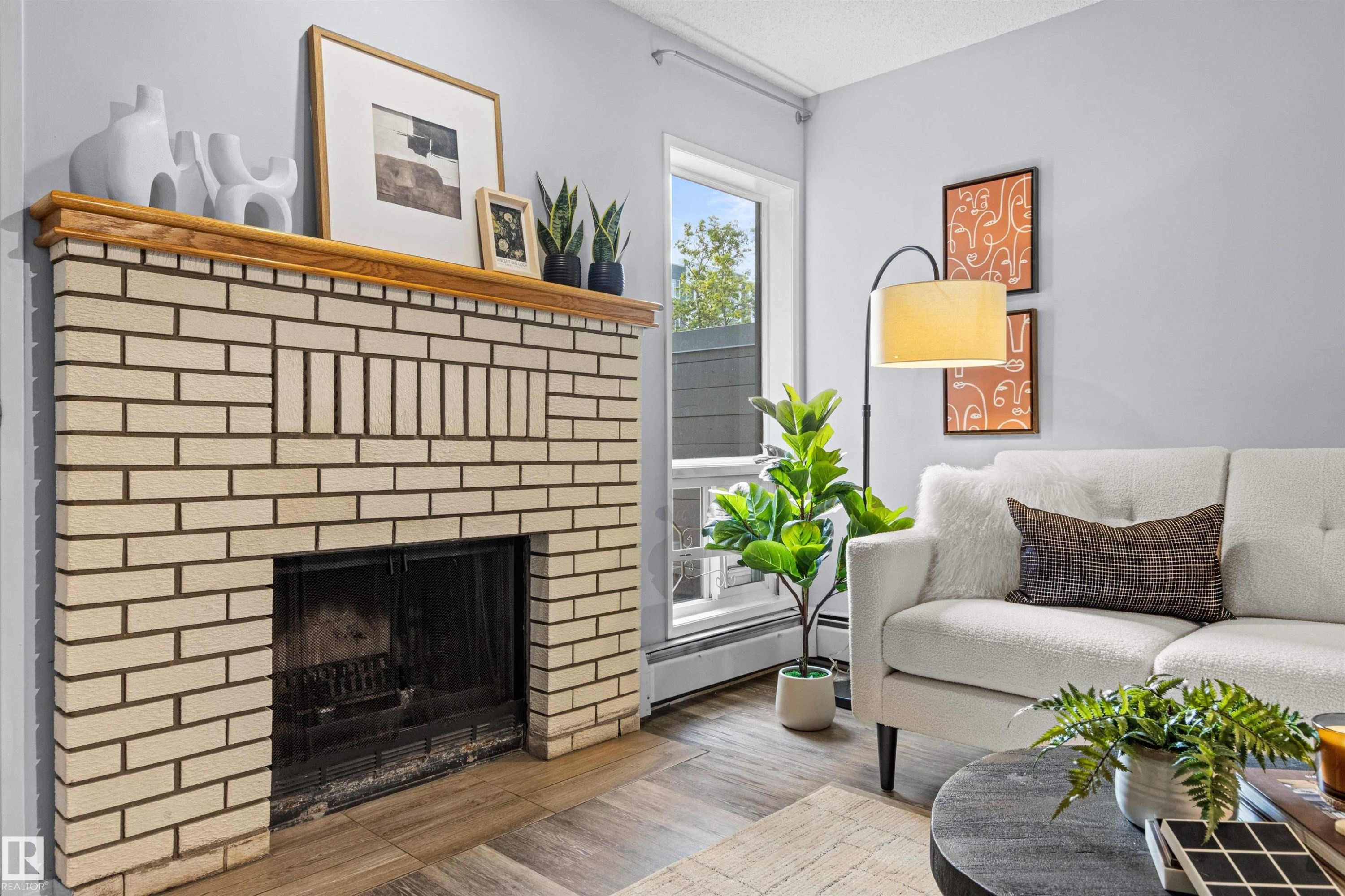 Fireplace with light brick surround and wood mantle - #7 10032 113 St Nw, Edmonton, AB