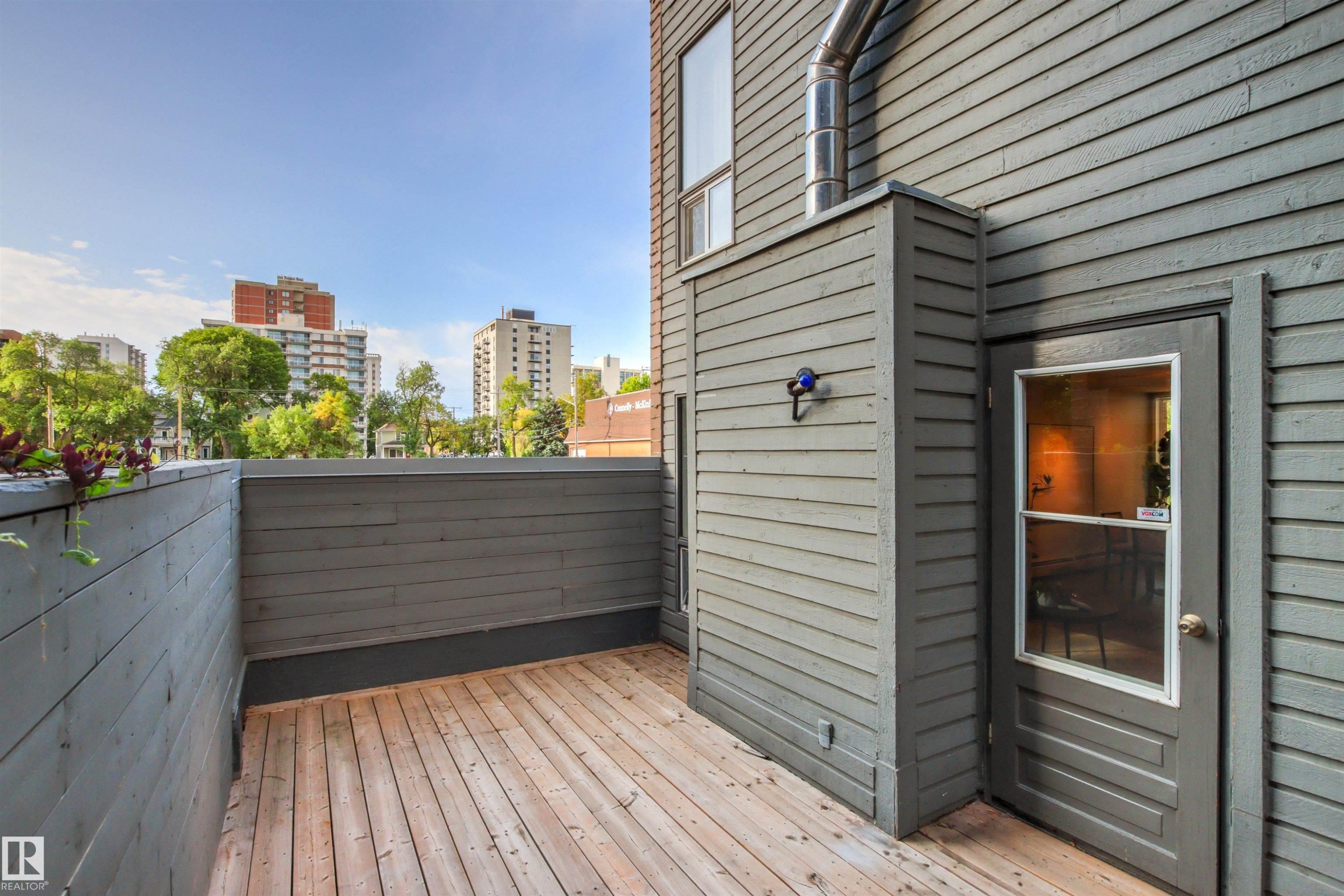 Private outdoor deck with wood flooring and horizontal slat privacy walls - #7 10032 113 St Nw, Edmonton, AB