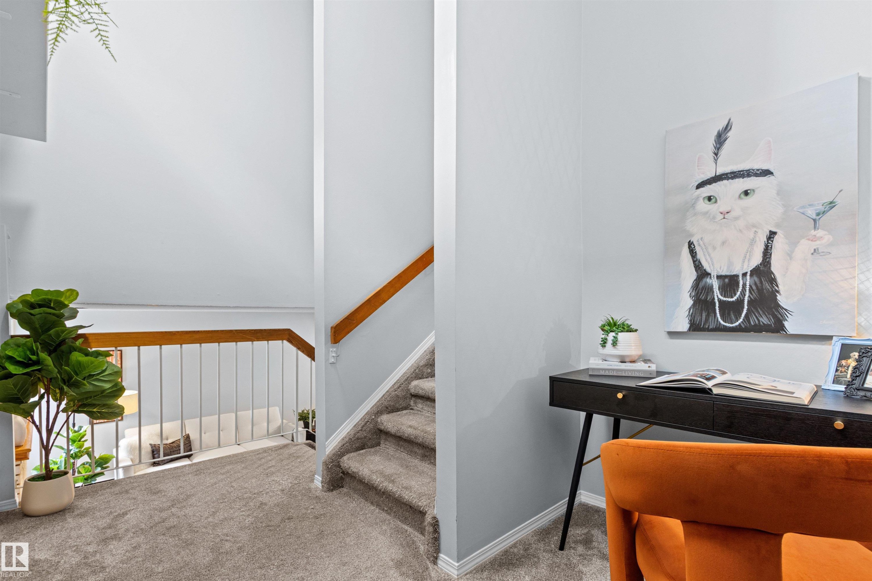 Carpeted hallway with a wood handrail and painted balusters - #7 10032 113 St Nw, Edmonton, AB