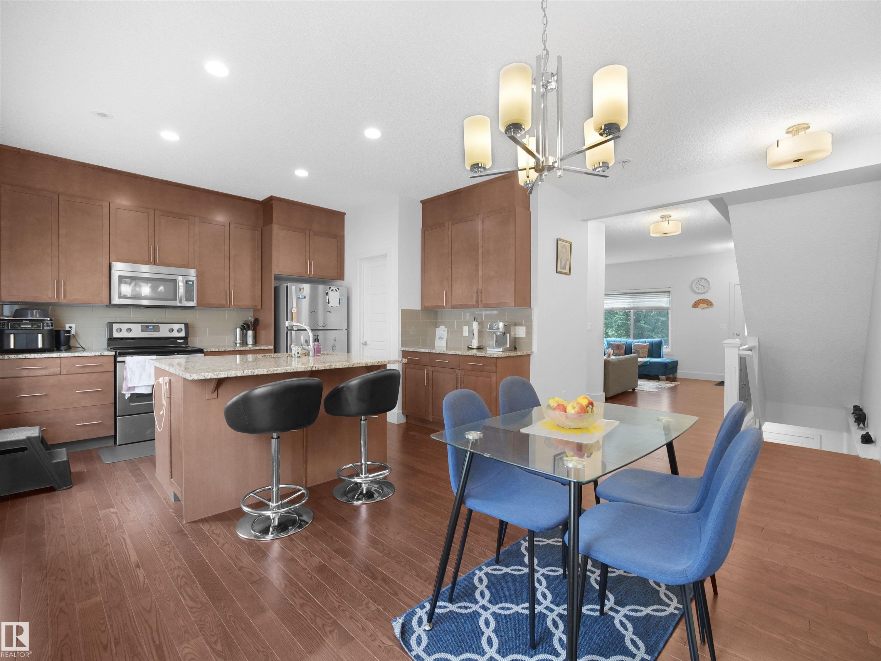 Kitchen featuring wood-finish flooring, recessed lighting, and a center island with a stone countertop - #40 2003 Rabbit Hill Rd Nw, Edmonton, AB