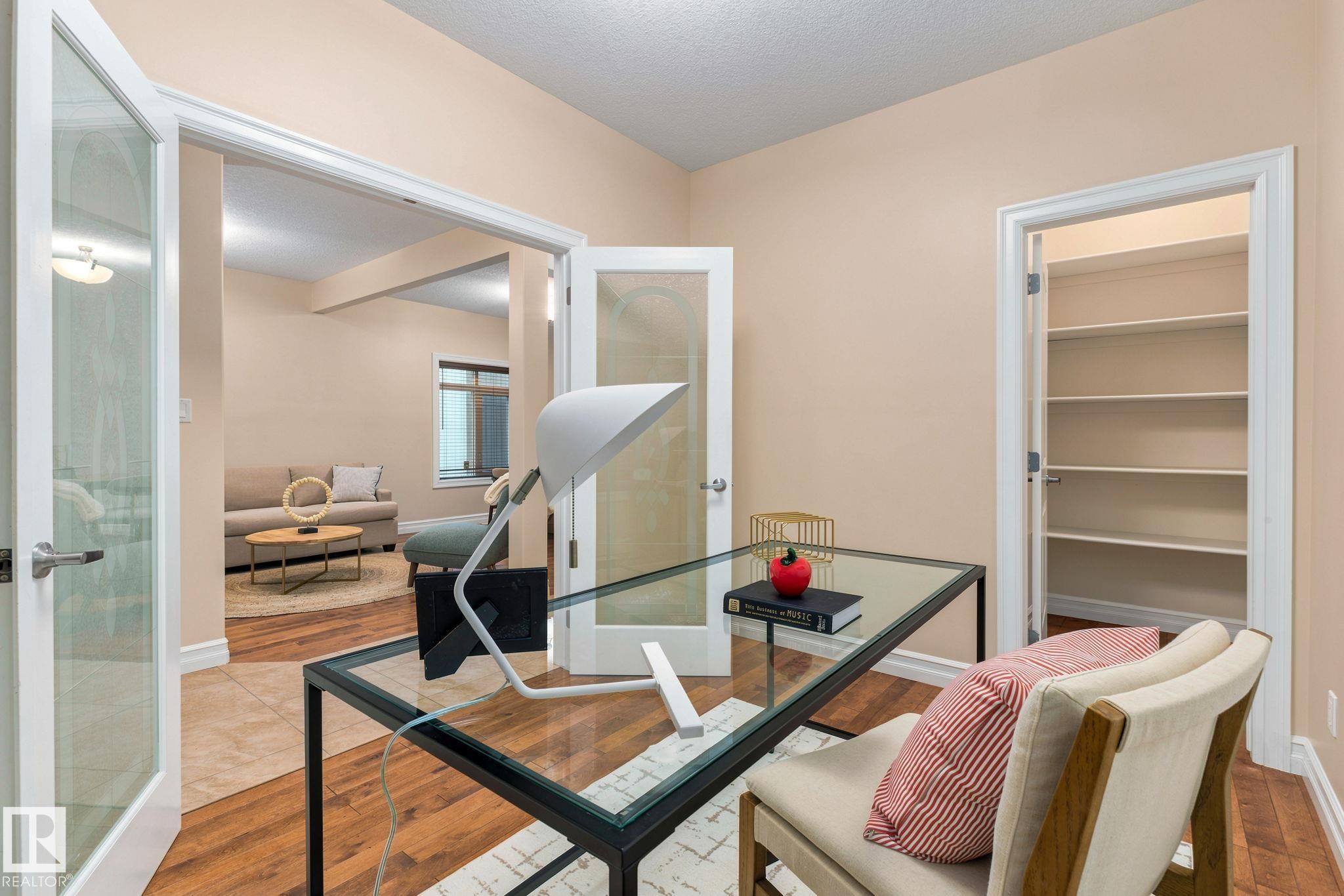 Wood-finish flooring throughout, complemented by a built-in shelving unit - 10143 123 Street Nw, Edmonton, AB