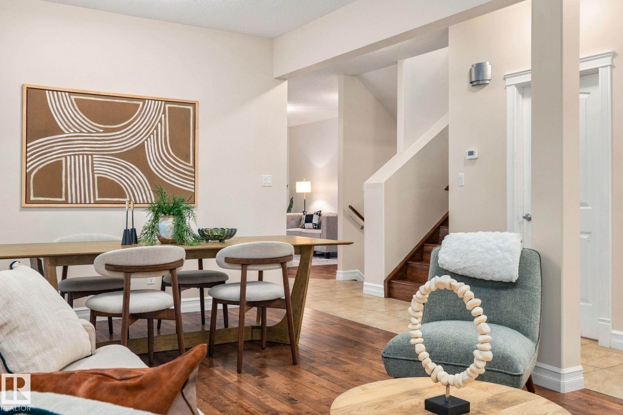 Hardwood flooring, painted walls, wood staircase, white trim, and a built-in wall sconce - 10143 123 Street Nw, Edmonton, AB