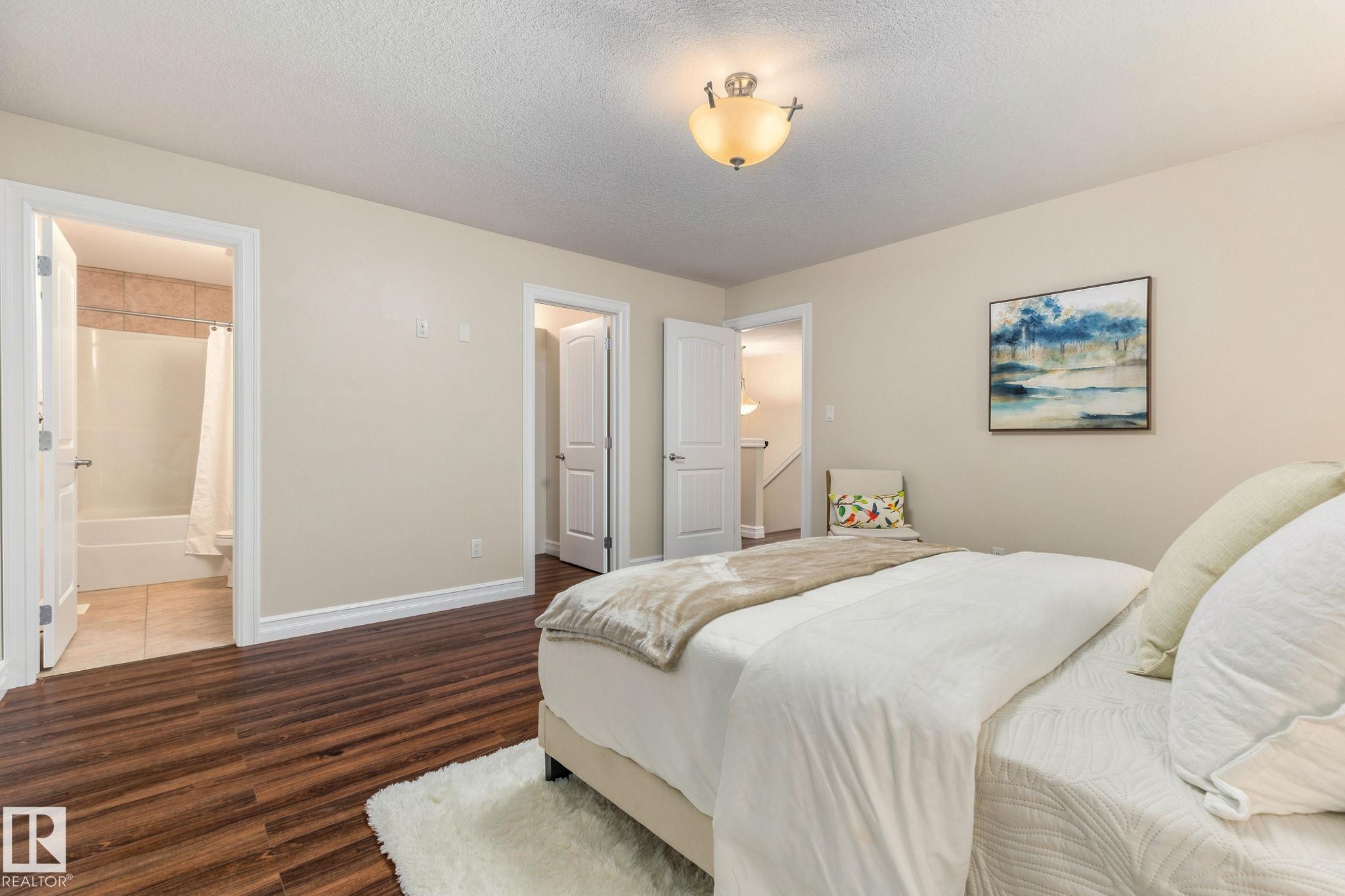 Wood-finish flooring, neutral wall tones, and white trim throughout - 10143 123 Street Nw, Edmonton, AB
