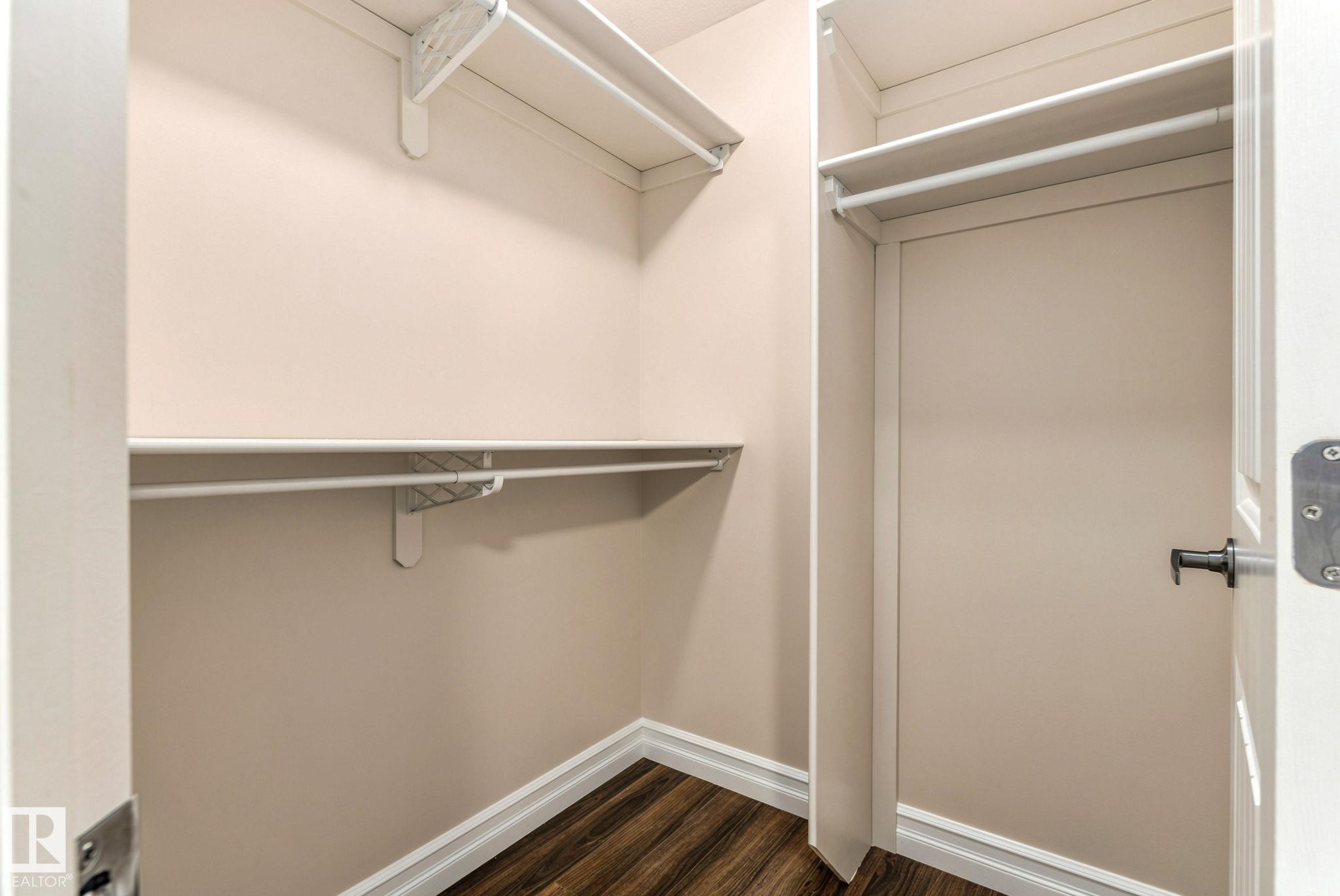 Walk-in closet with multi-level shelving, hanging rods, and wood-finish flooring - 10143 123 Street Nw, Edmonton, AB